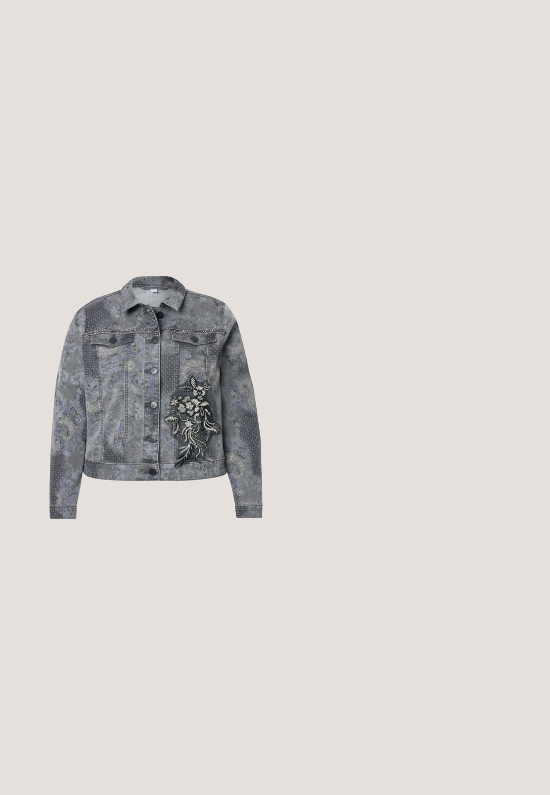 Grijze denimjas met bloemen borduurwerk en metallic accenten, voorzien van een kraag, knoopsluiting en textuurpatronen.; Lichtgrijs shirt met korte mouwen, een ronde halslijn en zilveren paillettenversieringen op beide mouwen.; Zwarte high-waist rechte jeans met metalen knoop, voorzakken en kleine zilveren studs langs de buitenste zijnaad.; Zwarte suède enkellaars met een spitse neus en een slanke, gebogen hak. Subtiele textuur en glans geven het oppervlak een onderscheidend uiterlijk.; Zwarte leren schoudertas met verstelbare band, versierd met zilverkleurige ronde studs in een symmetrisch patroon aan de voorkant en zijkanten.; Een paar glanzende zilveren oorringen met een dikke, ronde vorm en een scharniersluiting op een witte achtergrond.