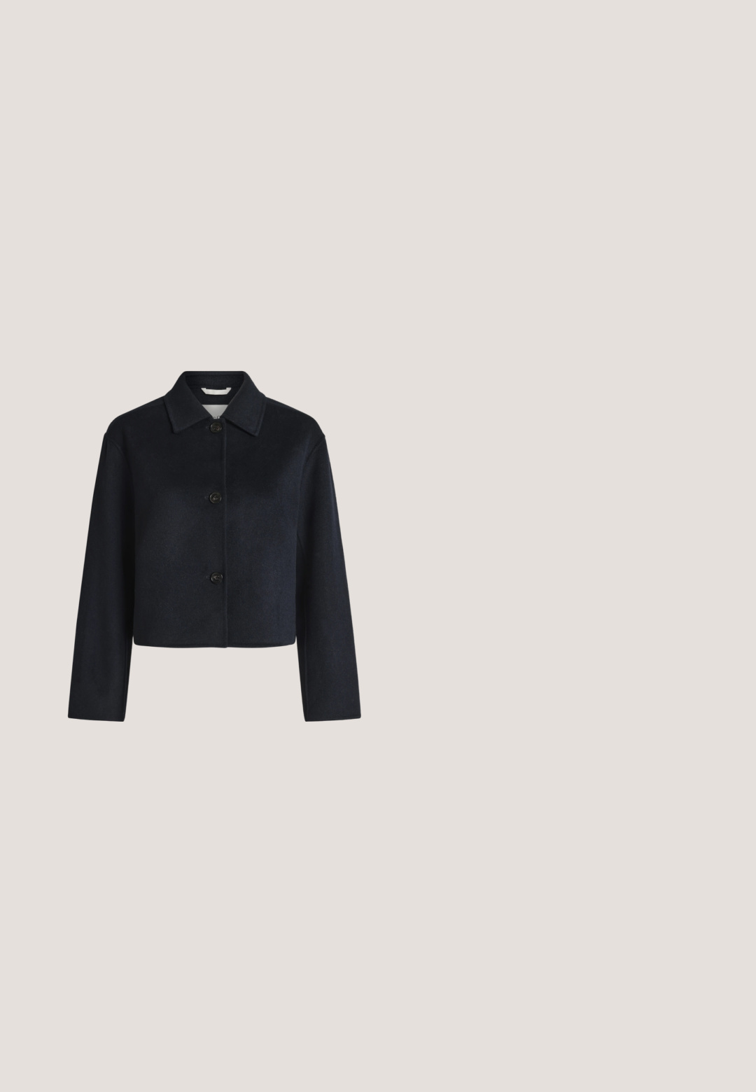Veste noire courte avec manches longues, trois boutons à l'avant et un col pointu sur un fond clair uni.; Chemise bleu clair à manches longues, boutonnée, avec motif à pois blancs et col pointu sur fond uni.; Jean bleu foncé à coupe droite, fabriqué en tissu denim. Caractéristiques : fermeture à bouton sur le devant et cinq poches.; Mocassins en daim bleu marine avec un bout pointu et un nœud décoratif sur le dessus. Semelle plate couleur beige avec des détails de couture minimalistes.; Grand sac cabas bleu marine avec longues anses à côté d'une pochette zippée bleu marine assortie avec un détail pompon.; Paire de boucles d’oreilles créoles en métal argenté brillant, avec un motif de croissant superposé, sur fond blanc uni.