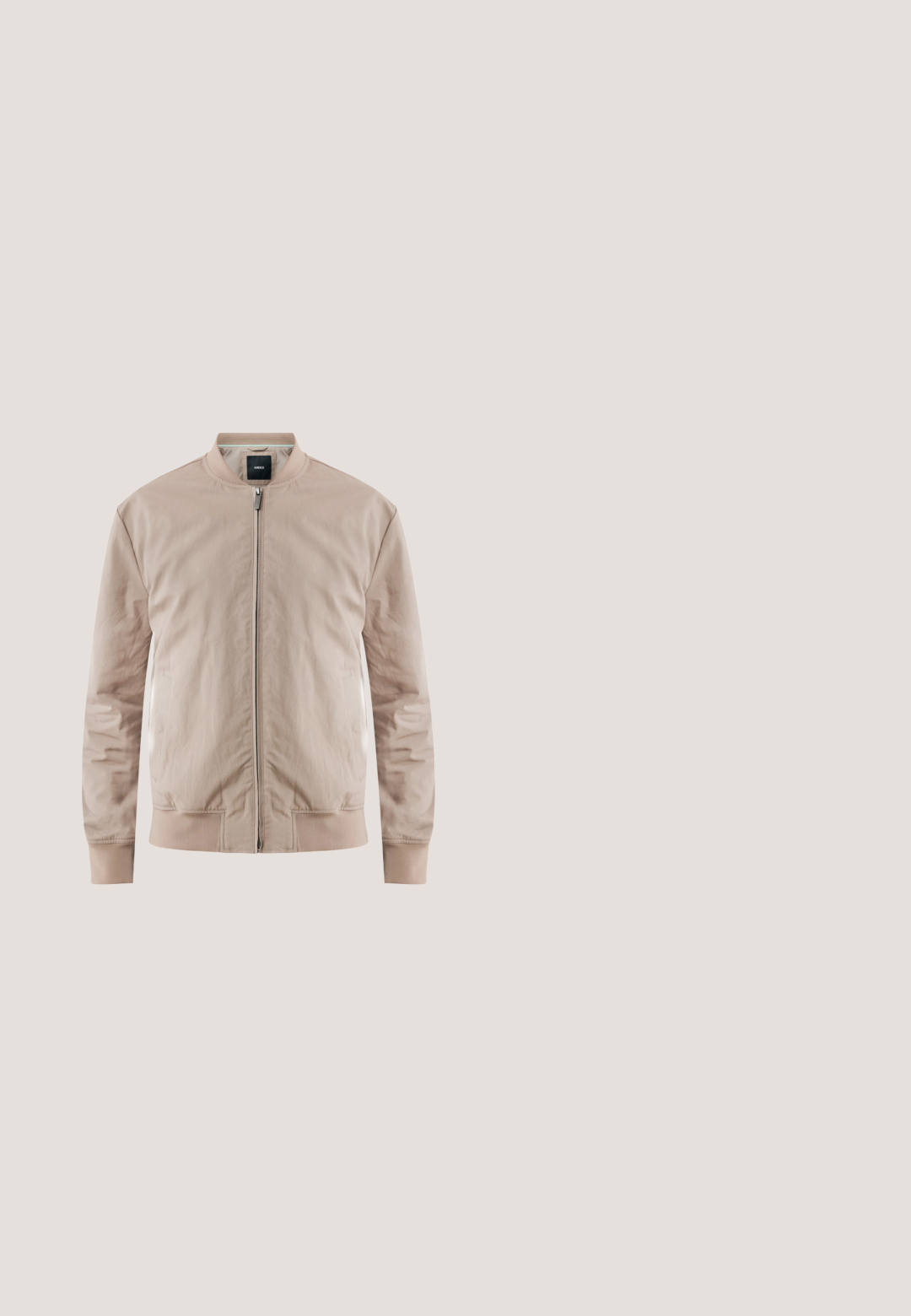 Chaqueta bomber beige con cremallera frontal, puños y dobladillo acanalados. Hecha de una tela suave y ligera. Presenta bolsillos laterales y cuello de pie.; Camisa polo beige de tela suave, con un collar clásico, tres botones en el cuello y mangas cortas.; Pantalones verde oliva hechos de una tela suave con un corte relajado, cinturilla elástica con cordón y dos pliegues delanteros para un diseño adicional.; Botín de ante marrón hasta el tobillo con puntera redonda, cuatro ojales para cordones y suela de goma negra. Presenta una lengüeta en la parte trasera.; Gafas de sol rectangulares de metal delgado y marrón con lentes oscuros y puntas de varilla negras, reposando sobre una superficie blanca.; Bolsa de tocador rectangular de cuero marrón con bolsillo frontal con cremallera y asa lateral sobre fondo blanco.