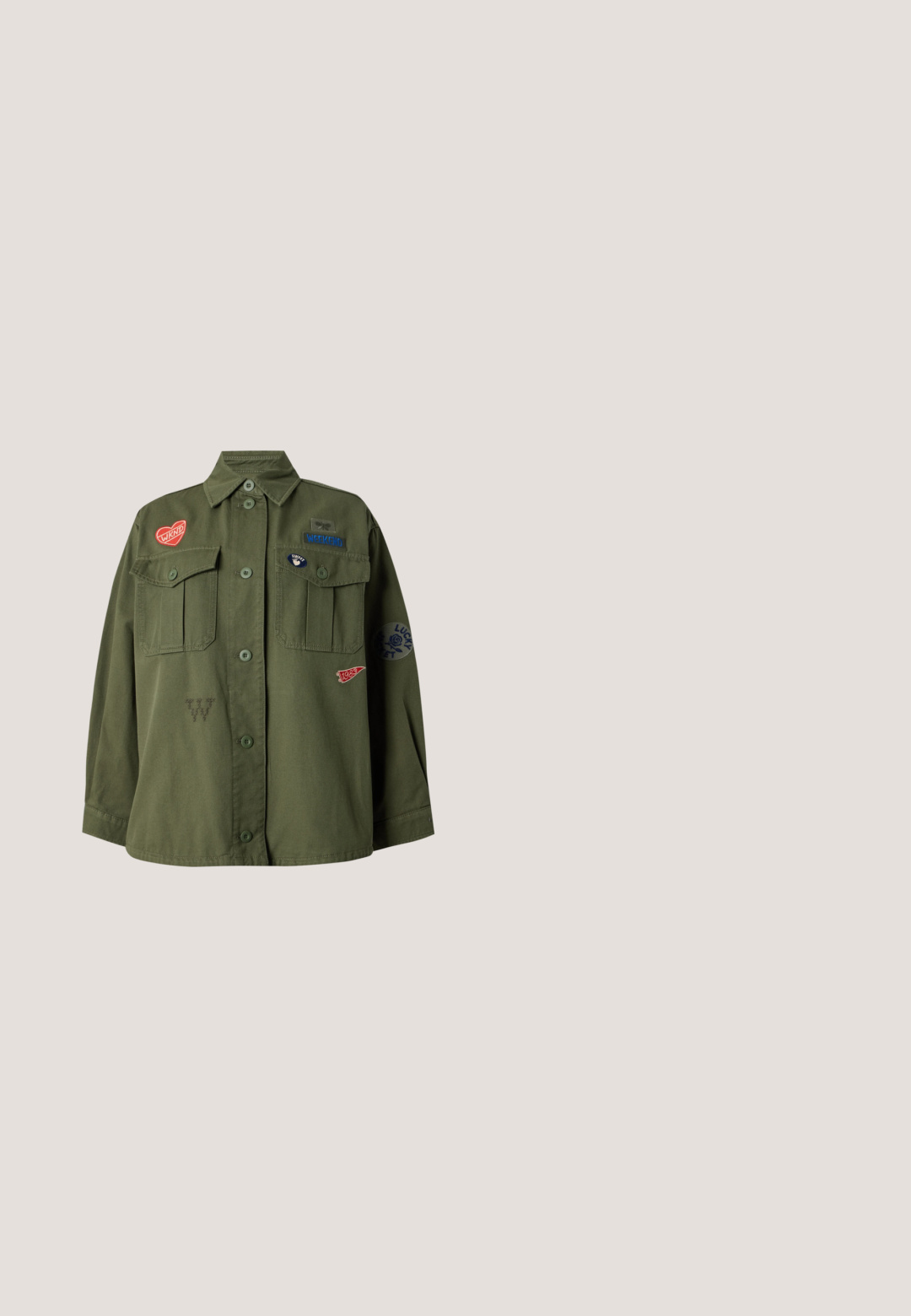 Groene jas met knopen, twee borstzakken en kleurrijke patches inclusief "WKND," "WEEKEND," "1983," en een roos met "LUCKY."; Wit cropped T-shirt met korte mouwen met kleine kleurrijke kralenapplicaties van fruit, waaronder banaan, appel, druiven en watermeloen, verspreid over de voorkant.; Donkerblauwe denim shorts met een klassieke snit, voorzien van vijf zakken, een knoopsluiting en contrasterende oranje stikdetails.; Platte schoen met een gele stoffen bovenkant met een bloemmotief in het rood. Puntige neus, minimalistisch ontwerp en een zwarte rubberen zool.; Beige canvas draagtasje met korte handvatten, een afneembare schouderriem en een geborduurd vosshoofd op het voorvak.; Verstelbare zwarte koordarmband met afwisselend witte en gele kralen, een gouden bloemenbedel en een klein rechthoekig gouden label.