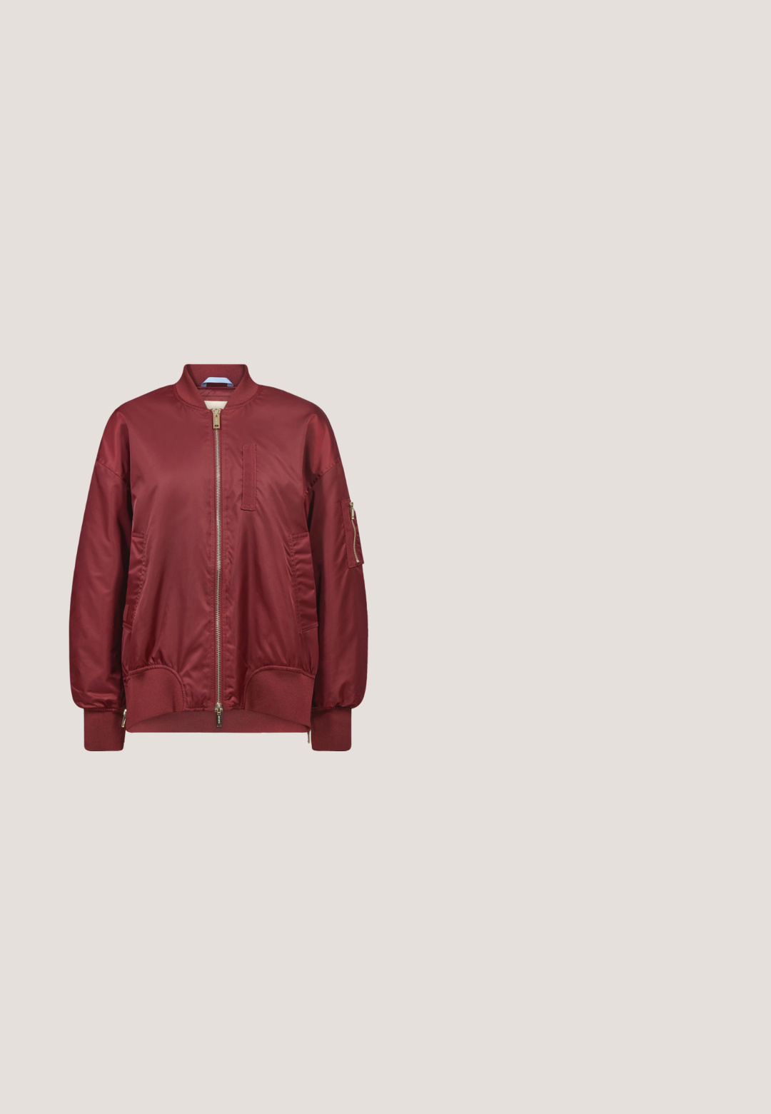 Bordeauxrote Bomberjacke mit vorderem Reißverschluss, geripptem Kragen, Bündchen und Saum, zwei Seitentaschen und einer Reißverschlusstasche am linken Ärmel.; Oversized kurzärmliges T-Shirt in dunklemburgunderrot mit Rundhalsausschnitt und kleinem, mittig gesticktem Logo auf der Brust.; Weit geschnittene burgunderrote Hose mit elastischem Bund und Kordelzugverschluss, hergestellt aus einem weichen, bequemen Stoff.; Low-Top-Sneaker aus dunkelviolettem Wildleder mit weißer Ferse, weißen Seitenstreifen und einer dicken beigefarbenen strukturierten Sohle, von der Seite betrachtet.; Geflochtene burgunderrote Lederhandtasche in runder Form mit einem einzigen geflochtenen Griff. Verfügt über einen Reißverschluss und eine glatte Textur.; Goldring mit einem großen roten Stein, umgeben von kleinen klaren Edelsteinen, mit einer glatten Oberfläche und einem schlanken Banddesign.
