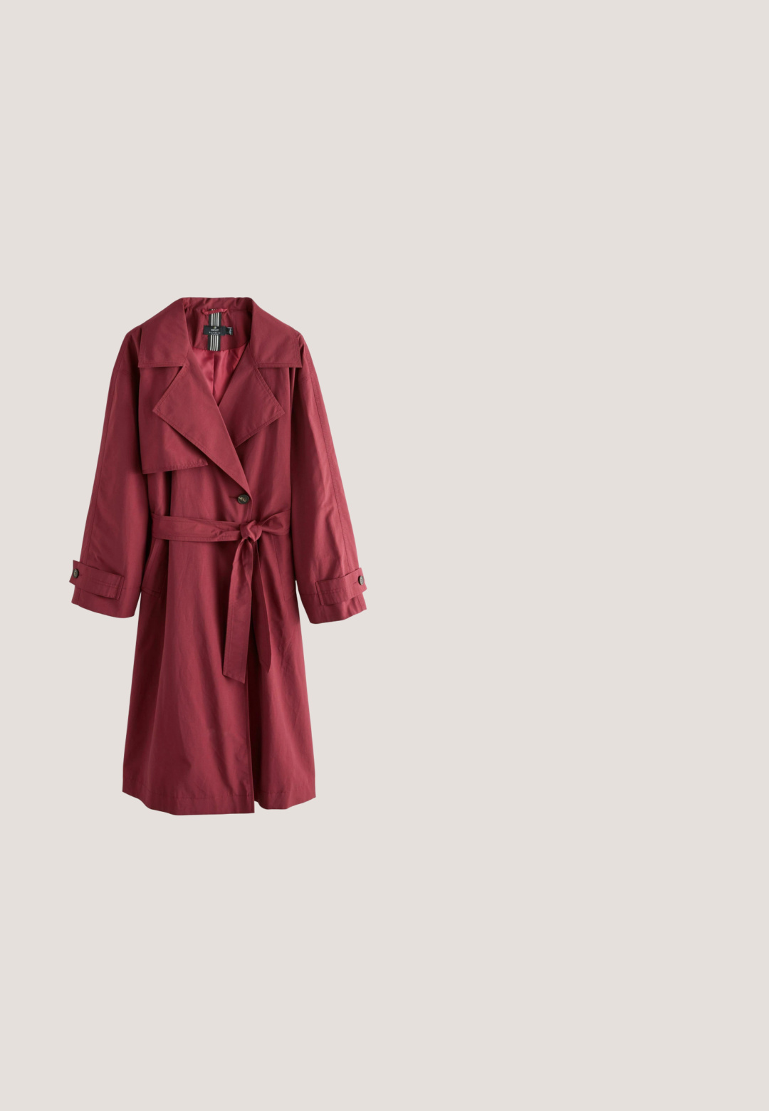 Lang bordeauxfarvet trenchcoat med brede revers, belted talje, enkelt knaplukning og ærmestropper, vist på hvid baggrund.; Sort kortærmet kjole med rund halsudskæring, fem knapper foran og let rynket talje for en afslappet pasform.; Sorte knæhøje støvler lavet af glat læder. De har en spids tå, blokhæle og elastiske sidepaneler for nem påtagning.; Sorte katteøje-solbriller med mørke linser og et gyldent logo på stængerne, vist på en ensartet lys baggrund.; Olivengrøn læder crossbody taske med gyldent lynlås og justerbar rem, glat tekstureret overflade, halvmåneform.; Guld åben ring med en enkelt klar gemstone og "SINGULARU" indgraveret indvendigt i banden, placeret mod en hvid baggrund.