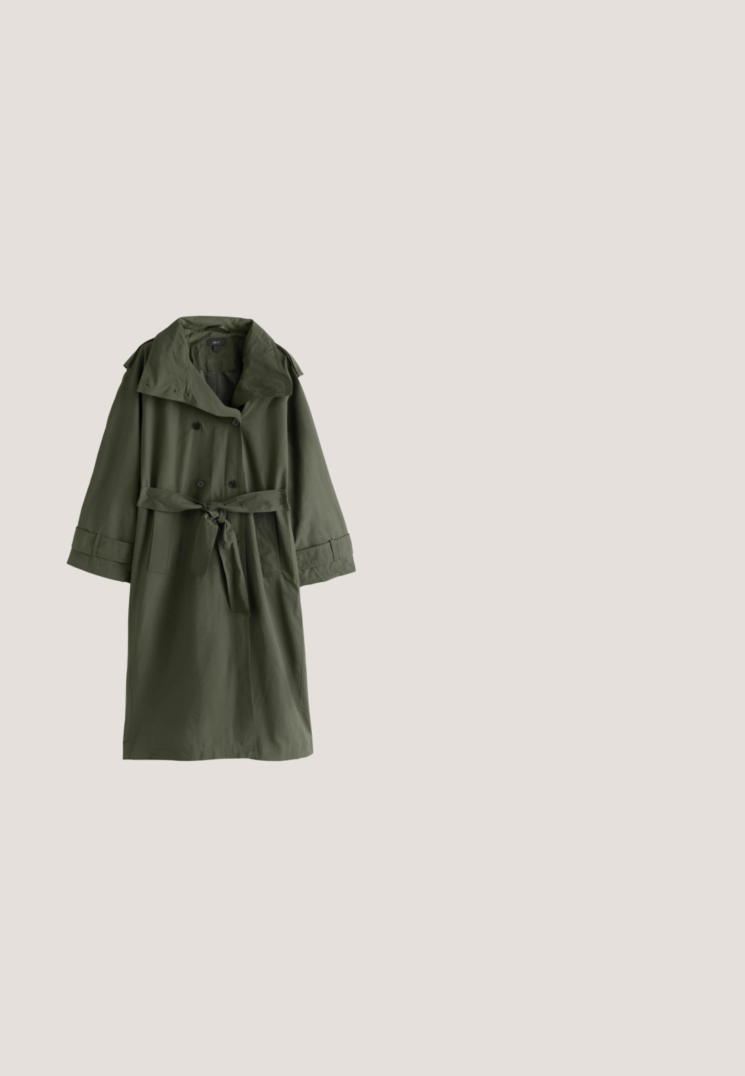 Lange olijfgroene trenchcoat met brede kraag, dubbele knopenrij, ceintuur in de taille en manchetbandjes aan de mouwen.; Raglan top met lange mouwen in olijfgroen aan de mouwen en zijkanten, en een wit voorpaneel, getoond op een effen achtergrond.; Donkergroene gebreide mouwloze trui-vest met V-hals en geribde randen aan de kraag, armsgaten en zoom.; Olijfgroene, losse broek met een elastische tailleband en trekkoord, voorzien van zijzakken en een lichtgewicht, gestructureerde stof.; Groene suede sneaker met een witte middenzool en een bruine rubberen loopzool. Voorzien van ronde veters en een gevoerde kraag voor extra comfort.; Donkergroene suède tote bag met twee lange handvatten, geometrische vorm en subtiele merklogo gecentreerd aan de voorkant. Gladde textuur.