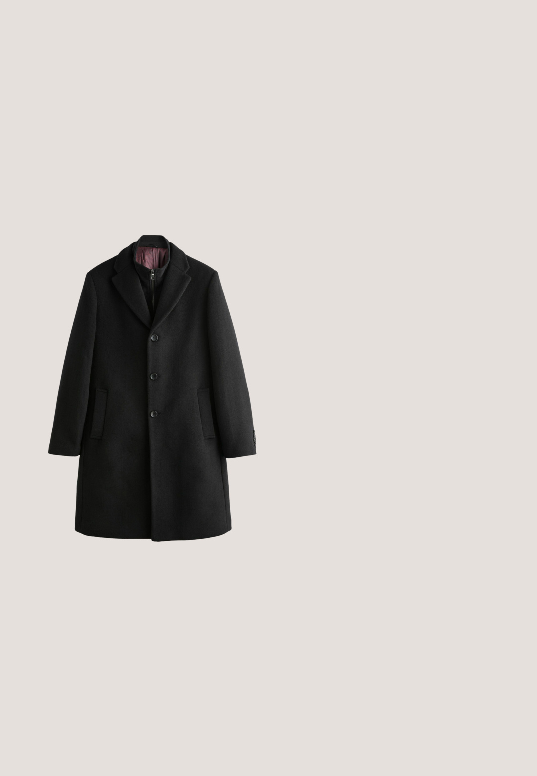Sort uldfrakke med klapkrave, to forlommer, tre-knaps lukning og en glat indvendig foring.; Sort langærmet rulneck-sweater med ribstrikkede manchetter og kant, vist på hvid baggrund.; Sort langærmet skjorte med knapper, spids krave og sorte knapper, vist på en hvid baggrund.; Sorte, brede fløjl bukser med en glat tekstur, der har to forlommer og et tætsiddende taljebånd.; Sort ruskindsankelstøvle med elastiske sidepaneler og en løkke; har en flad gummisål og minimalistisk design.; Sort læder kosmetikpose med lynlås, flad rektangulær form og subtil tekstureret overflade. Har et sidehåndtag til nem transport.