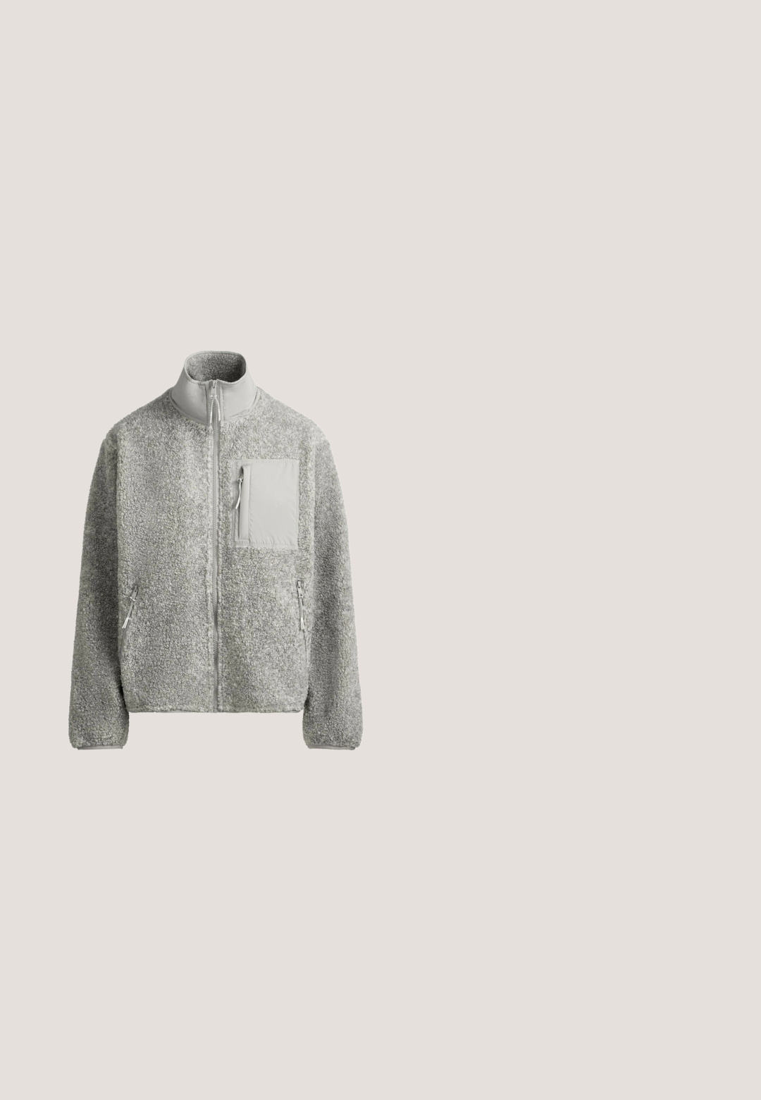 Veste polaire gris clair à fermeture éclair intégrale, col montant, deux poches latérales zippées et une poche poitrine zippée avec un panneau en tissu lisse.; Pull en maille aux tons gris et beige, présentant un motif géométrique, un ourlet et des poignets côtelés, avec un col rond et une coupe décontractée.; T-shirt blanc à manches courtes, col rond, avec des manches raglan et des détails de couture discrets sur le devant et les épaules, posé à plat sur un fond blanc.; Pantalon large en maille gris clair avec une taille élastique côtelée et des détails sur les panneaux latéraux, présenté sur fond blanc.; Bottines en daim beige avec un bout rond, des coutures décoratives et une semelle en caoutchouc profilée basse avec un motif en zigzag.; Sac à main texturé marron avec poignées courtes et bandoulière amovible, avec logo "Lancaster Paris" à l'avant et une étiquette en cuir.
