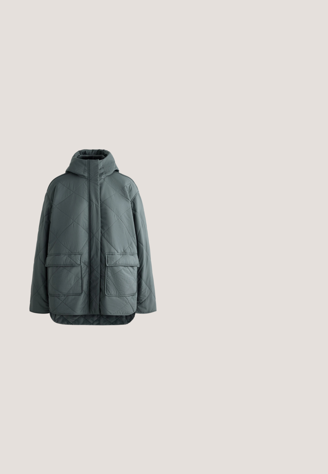 Veste matelassée verte avec col montant, fermeture à glissière frontale et deux grandes poches à rabat. Présente une finition texturée et douce.; Pull cache-cœur à manches longues beige clair avec col en V et détail de lien côté droit à la taille, tissu tricoté texturé.; Pantalons en stretch noirs avec une taille élastique, longueur cropped et fentes latérales aux ourlets pour un confort de mouvement. Texture lisse.; Baskets en cuir blanc avec un bout arrondi, des lacets plats et un accent texturé doré sur le talon. Elles présentent une semelle épaisse et flexible.; Grand sac de voyage en cuir noir avec deux longues poignées et une poignée courte, sur un fond clair uni.; Bracelet chaîne en argent avec une moitié composée de petites mailles liées et l'autre moitié ornée de petits cristaux clairs.