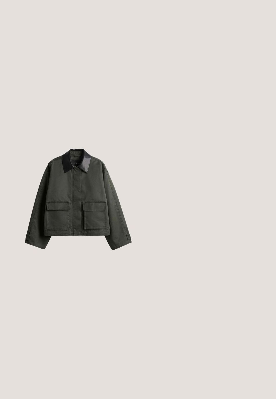 Dunkelgrüne kurze Jacke mit weiten langen Ärmeln, schwarzem Leder-Spitzenkragen, vorderen Druckknöpfen und zwei großen Klappentaschen.; Olivengrünes Kurzarmoberteil mit lockerer Passform, strukturiertem Stoff, rundem Halsausschnitt und gerafftem Saum auf Taillenhöhe.; Weit geschnittene, gekürzte Hosen mit großem abstraktem Blumenmuster in Dunkelgrün und Schwarz und hohem Bund.; Brauner Wildlederloafer mit schwarzer flacher Sohle und Mokassin-artiger Naht an der Spitze, von der Seite auf weißem Hintergrund gezeigt.; Dunkelgrüne Wildleder-Handtasche mit rechteckigem Griffausschnitt und verstellbarem Schulterriemen auf weißem Hintergrund.; Halskette mit polierten grünen Jadeperlen auf einer Goldkette mit Karabinerverschluss vor hellem Hintergrund.