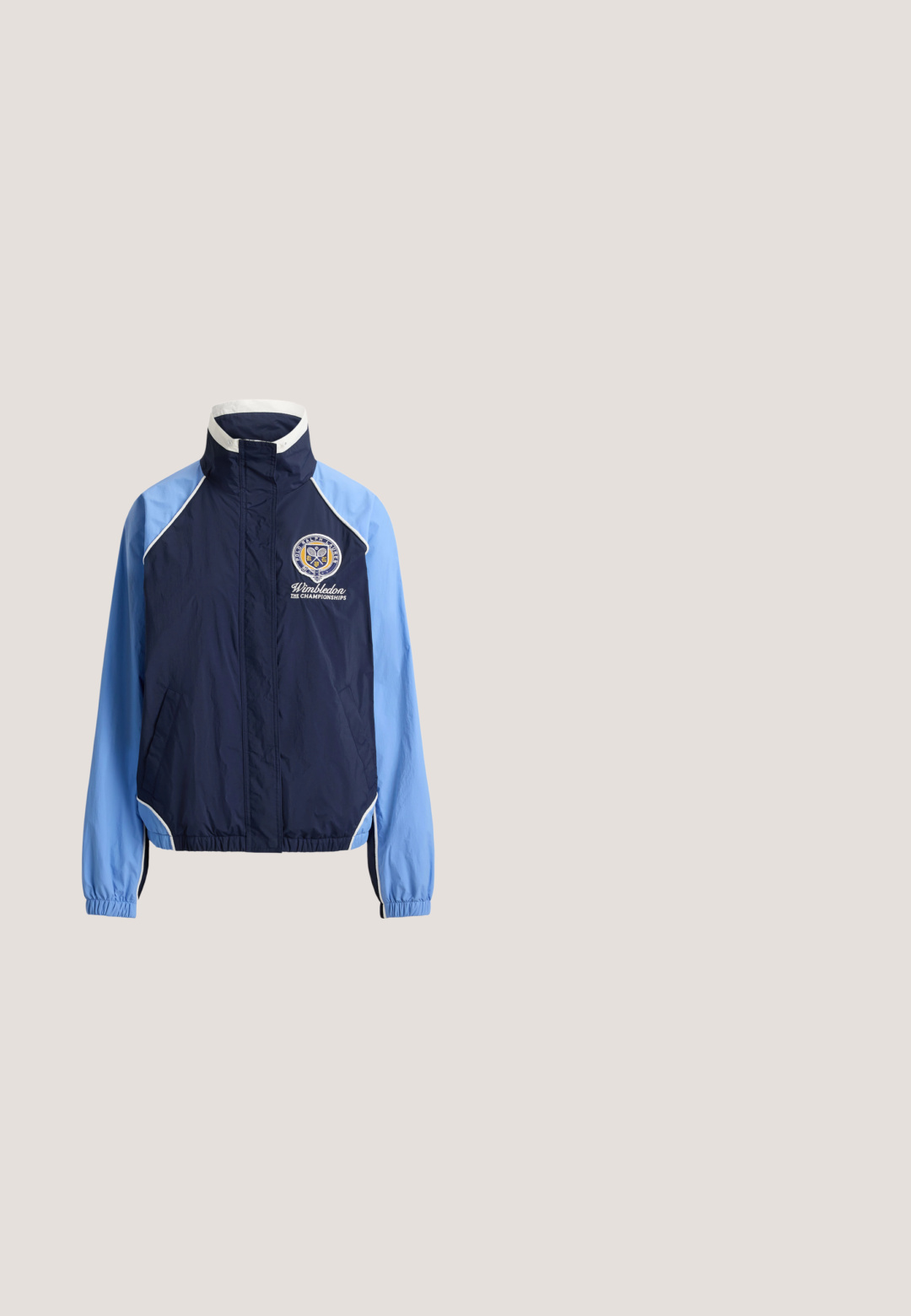 Marineblå og lyseblå hættejakke med hvid kant, elastiske manchetter og Wimbledon Championships-logo på venstre bryst.; Sort kortærmet rash guard lavet af strækbart materiale, med et hvidt "ROXY" logo på forsiden og en rund halsudskæring.; Hvide frottéshorts med elastisk talje, snøre og mørkeblå kant langs kanterne.; Hvid, lyseblå og gul lavtop-sneaker med snørebånd, struktureret brun sål og ruskindsdetaljer set fra siden på en hvid baggrund.; Hvid rektangulær håndledstaske med marineblå kant og Polo Ralph Lauren New York-logo med en polospiller til hest i marineblåt tråd.; Guld- og sølvøreringe med en blandet metallisk finish, der har et glat, buet design og en sømløs lukning.