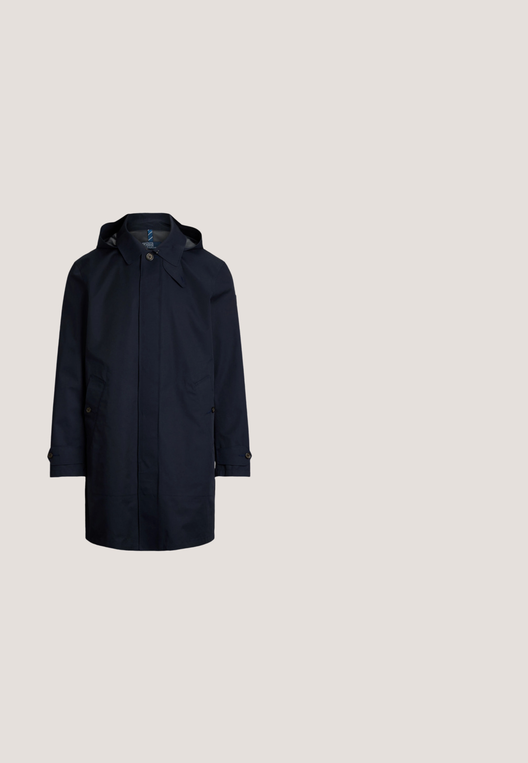 Abrigo impermeable azul marino con capucha, cierre de botones, dos bolsillos frontales y detalles en las mangas. Acabado exterior suave.; Polo de manga larga azul marino con cuello, dos botones y pequeño logo bordado en el pecho izquierdo.; Camisa de manga larga con botones, de rayas verticales azules y blancas, con cuello y logo de Polo Ralph Lauren en el pecho.; Pantalones chinos beige de frente plano con trabillas para cinturón, bolsillos laterales y cierre con botón en la cintura sobre fondo blanco.; Mocasín marrón de ante con costuras blancas y suela de goma blanca, visto de lado sobre un fondo claro.; Cinturón de cuero negro con hebilla rectangular de plata estampada con un jugador de polo montado a caballo sosteniendo un mástil.