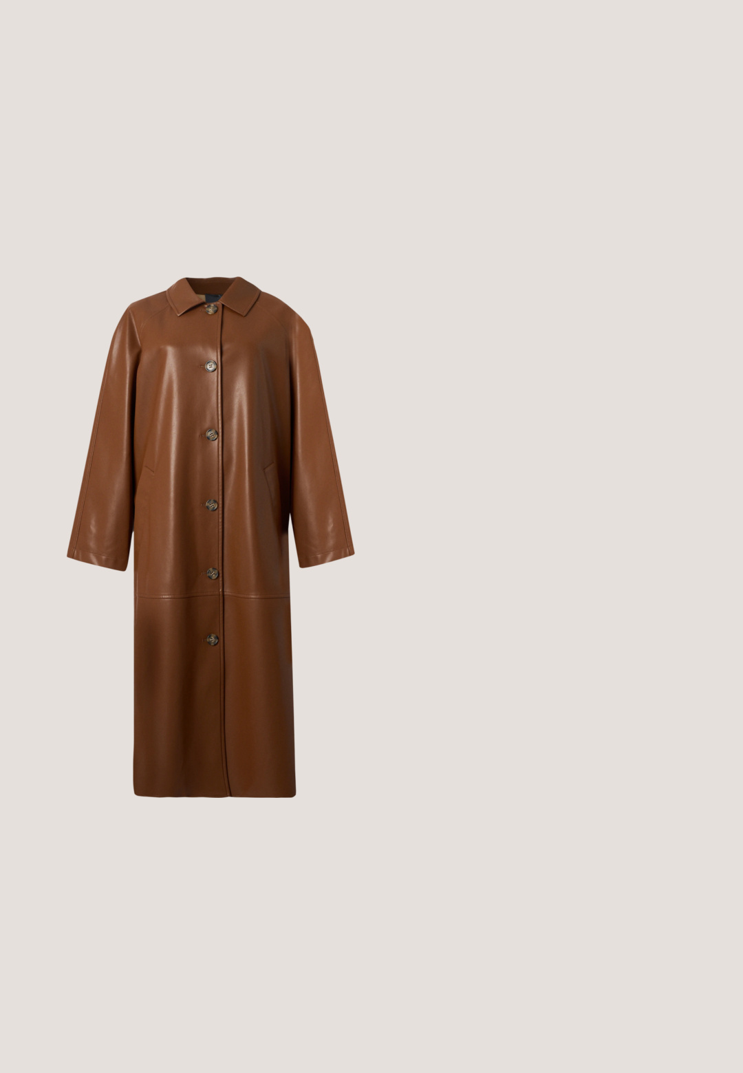 Manteau long en cuir marron avec col et six boutons devant, manches longues et poches latérales, présenté sur un fond uni.; Blouse bleu marine à manches longues avec des poignets en dentelle, des manches bouffantes, un col rond et une petite fermeture par bouton à l'arrière.; Jean en denim bleu foncé, coupe slim, avec bouton frontal, passants pour ceinture et cinq poches, présenté sur un fond clair uni.; Bottine en cuir marron avec un bout rond et un petit talon block, dotée de panneaux latéraux élastiques et d'une finition lisse et brillante.; Sac fourre-tout beige en cuir lisse, doté de deux poignées robustes et d'accents de quincaillerie dorée, avec un détail à cordon ajustable.; Ensemble collier et bracelet ton or avec motifs floraux et feuilles en cristal clair, tous deux avec fermoirs chaîne réglables sur fond blanc.