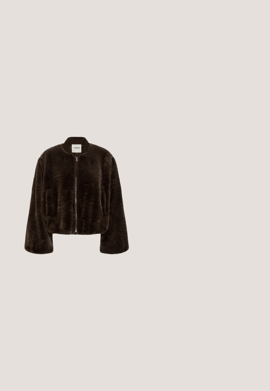 Donkerbruine imitatiebontjas met lange mouwen, voorrits, geribde kraag en zijzakken, weergegeven op een effen witte achtergrond.; Bruine cardigan van zacht materiaal, met een ronde hals, lange mouwen en zwarte knopen aan de voorkant.; Donkergroene geribbelde top met korte mouwen, opgeblazen schouders en een witte geschulpte rand bij de halslijn en mouwuiteinden.; Bruine jeans met een hoge taille en rechte pijpen, met een knoop- en ritssluiting aan de voorkant, riemlussen en zijkanten en achterzakken.; Bruine Puma sneaker met een beige streep en logo, met veters, rustend op een gestructureerde beige ondergrond.; Bruine leren handtas met een gestructureerde afwerking, ronde handvatten en een afneembare schouderband. Voorzien van zilveren hardware en een ritssluiting.