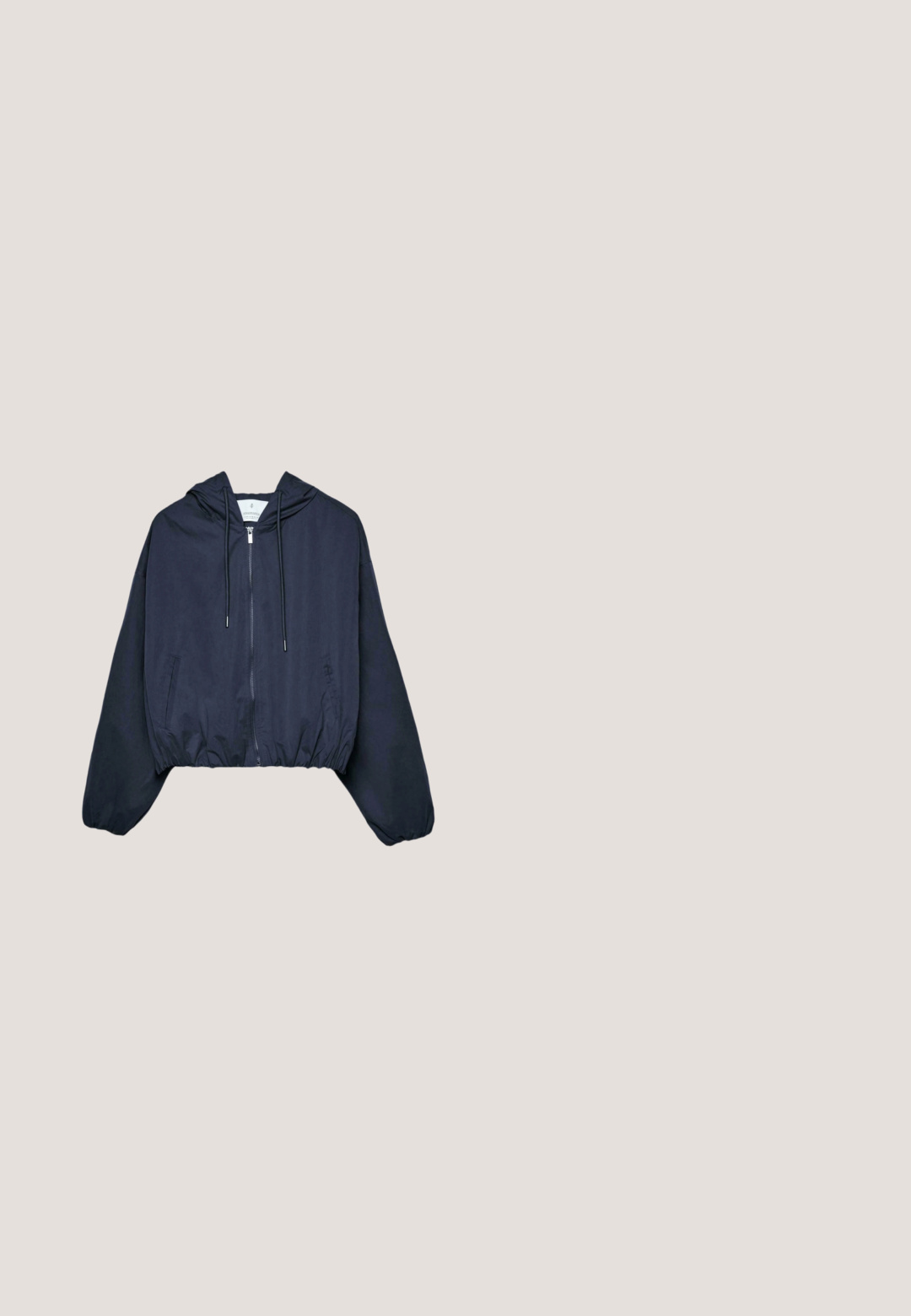Veste courte à capuche bleu marine avec fermeture éclair frontale, capuche à cordon de serrage, ourlet élastique et poches latérales sur fond blanc.; Combinaison sans manches bleu marine avec col en V et bordure blanche le long de l'encolure, avec un petit détail œillet dans le dos.; Tongs en caoutchouc bleu marine avec semelle texturée et brides en forme de Y, isolées sur un fond gris clair uni.; Lunettes de soleil bleu marine avec un design félin élégant, monture en plastique et verres teintés marron. Présente un logo discret sur la branche.; Sac d’épaule matelassé bleu avec sangles réglables noires et fermeture éclair, tissu doux avec détails froncés.; Bracelet chaîne en argent avec fermoir homard et chaîne d'extension réglable sur fond blanc.