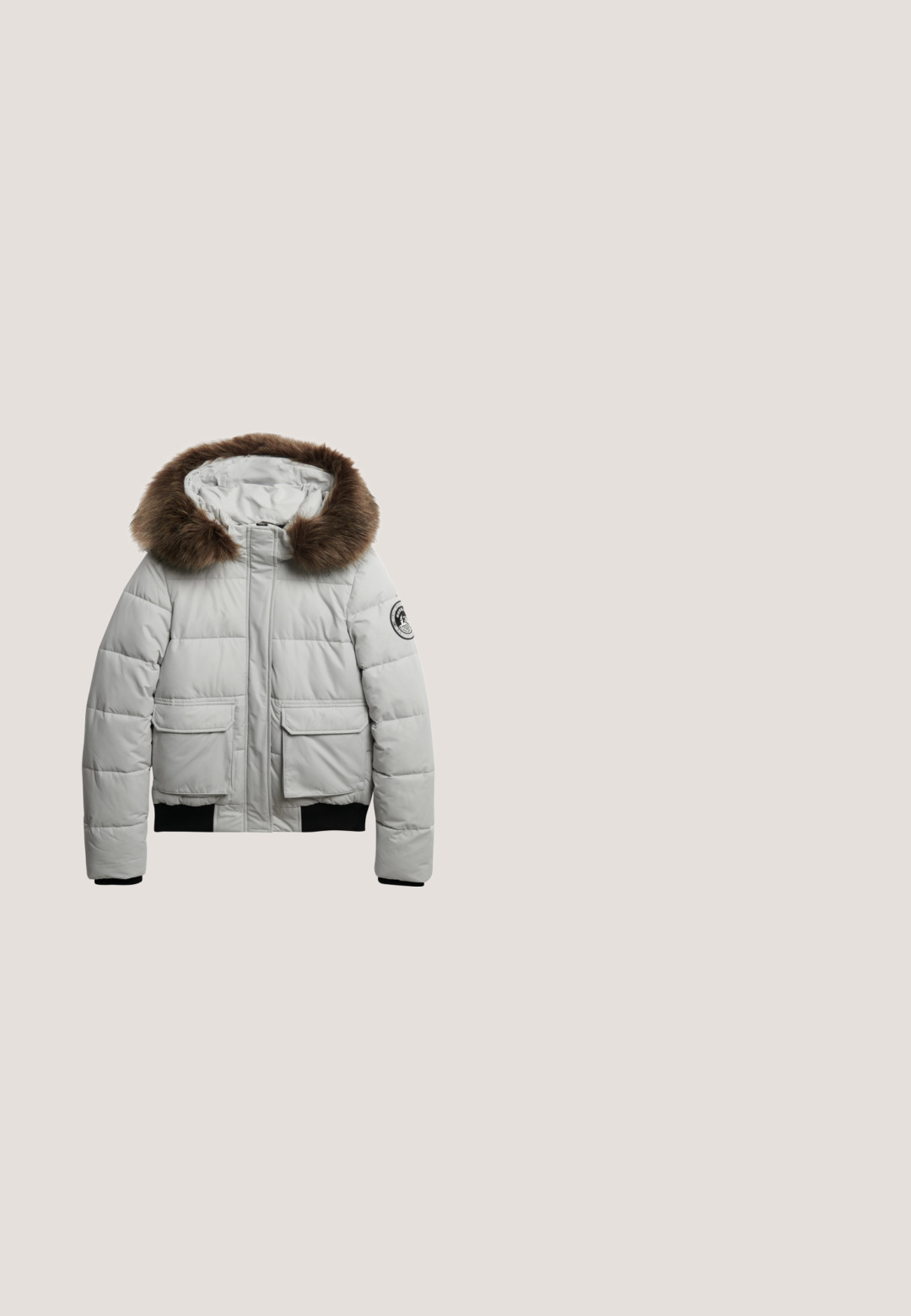 Lichtgrijze pufferjack met een met bont afgewerkte capuchon, voorzien van twee zijzakken en geribbelde manchetten voor een fijne pasvorm.; Superdry & Co ATHLETIC ESSENTIALS  - Hoodie - grey marl; Witte mouwloze T-shirt van katoen, met een sprankelend zilver en zwart grafisch tekstontwerp. Etiket genaaid aan de onderkant links.; Grijze joggingbroek met een koord in de taille, zijzakken en marineblauwe zijstrepen. Zachte textuur, wijde pijpen en geborduurd logo.; Witte lage sneaker met kanten patroon aan de zijkanten, rubberen zool en studs op de neus, met witte veters, zijaanzicht.; Witte gequiltte stof tas met twee handvatten aan de bovenkant, een verstelbare schouderband, voorzakken met rits en een klein voorvak met metalen hardware.