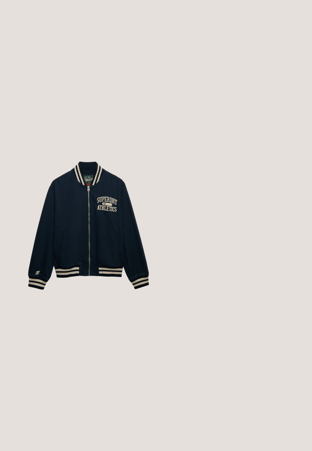 Chaqueta bomber azul marino con rayas cremas en el cuello y los puños. Cuenta con bordado "Superdry Athletics" en el pecho y dos bolsillos laterales.; Suéter beige claro con textura acanalada, mangas largas, cuello redondo y detalle sutil de marca. Textura suave y diseño de ajuste relajado.; Camiseta de algodón verde con cuello redondo, mangas cortas y un pequeño logo rojo de Levi's en el lado izquierdo del pecho. Textura suave, corte estándar.; Pantalones vaqueros de pierna ancha en azul oscuro con dobladillos enrollados, botón delantero y costuras de contraste sobre un fondo blanco liso.; Bota corta de gamuza beige con punta redondeada, con un detalle marrón en la parte superior. Forro interior suave y suela de goma texturizada.; Strellson ABBEY  - Bandolera - d.braun