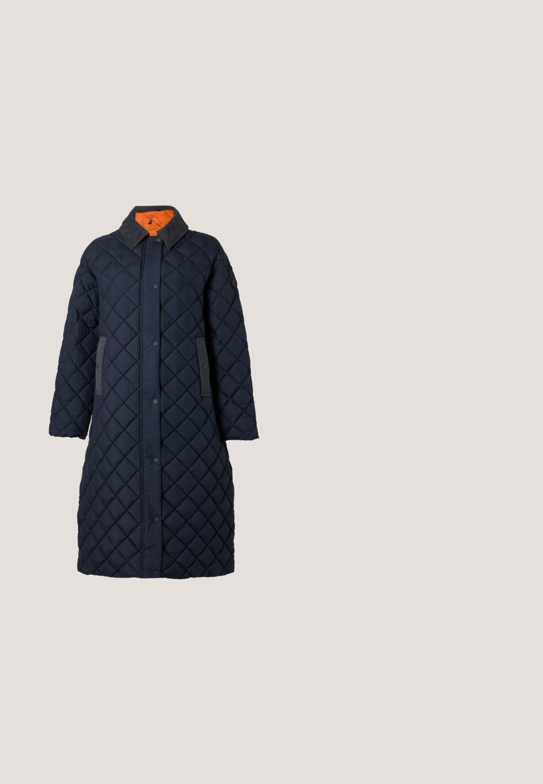 Long manteau matelassé bleu marine avec boutons-pression, col foncé, deux poches latérales et doublure orange visible à l'intérieur du col.; Pull bleu marine à col en V avec manches longues, poignets et ourlet côtelés, présenté sur un fond gris clair.; Pantalon en velours côtelé bleu marine avec taille haute, jambes droites et deux poches avant. Doté d'une fermeture par bouton et glissière. Tissu texturé.; Mocassin en suede bordeaux avec semelle noire, petit talon, détails de couture et une sangle traversant l'empeigne.; Sac à main en daim bleu avec un corps arrondi et une bandoulière unique. Comprend une poche zippée et un détail de logo discret à l'avant.; Boucles d'oreilles en argent avec un design circulaire et une pierre précieuse verte au centre, présentant une texture lisse et une finition polie.