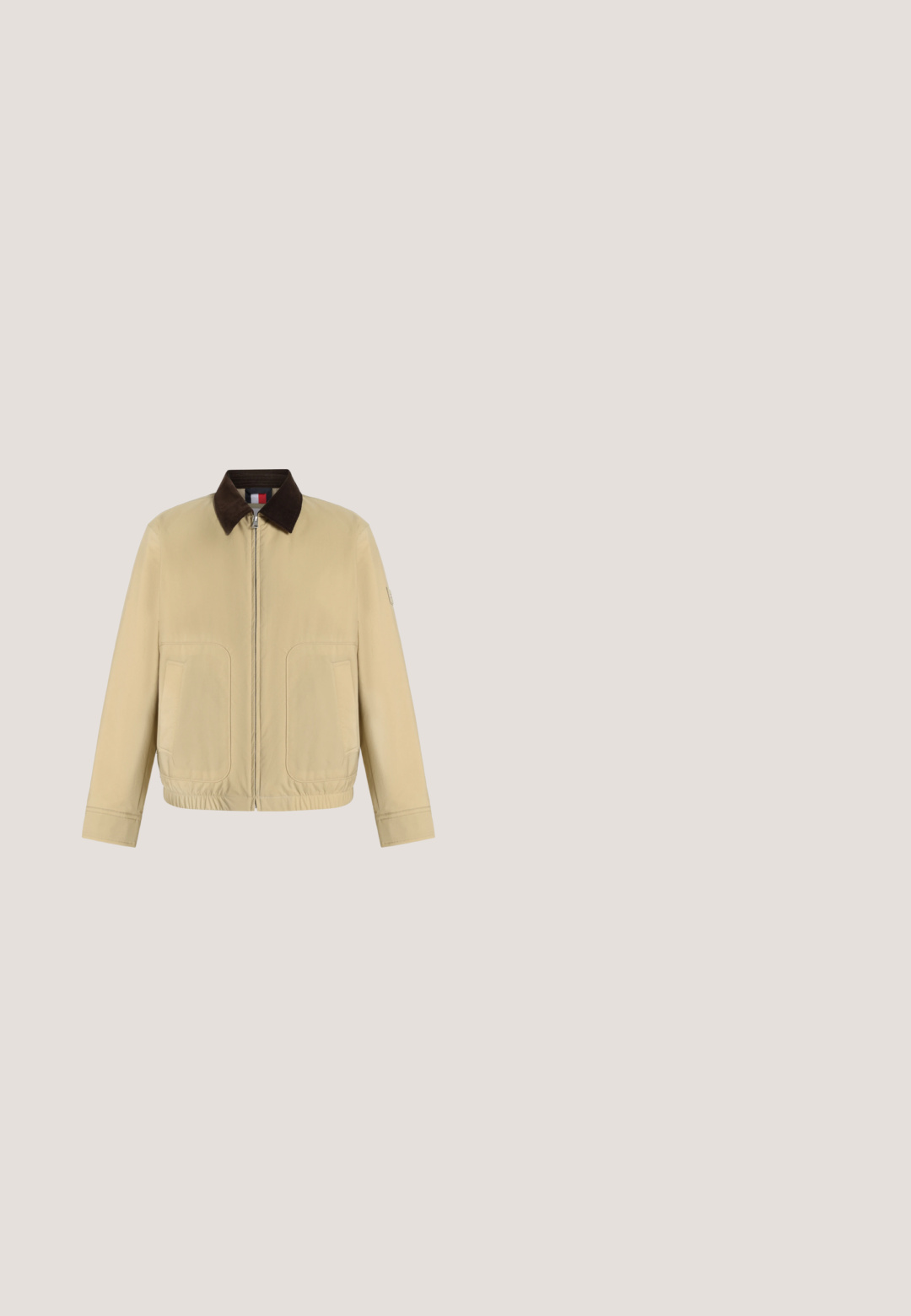 Veste beige avec fermeture éclair, col marron foncé, deux poches avant, manches longues et ourlet élastique, présentée sur un fond blanc uni.; Pull à col rond en maille blanche texturée avec manches longues et petit logo brodé sur le côté gauche de la poitrine.; Chemise bleue à manches longues avec des rayures verticales blanches et une poche poitrine, présentée sur un fond blanc uni.; Pantalon beige à jambes droites avec passants de ceinture, fermeture avant par bouton et zip, poches latérales et détail plissé près de la taille.; Mocassin en daim marron avec semelle blanche et détail métallique, flottant au-dessus d'un tapis clair à côté d'un meuble rond marron brillant.; Sac fourre-tout en toile blanche avec des accents bleu marine. Dispose de deux poignées robustes et d'un écusson logo à l'avant. Forme rectangulaire.