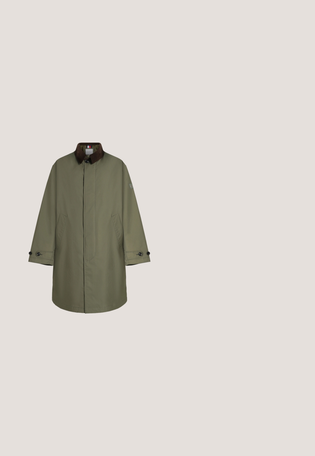 Abrigo largo de color verde oliva con cuello marrón oscuro, botones delanteros ocultos, dos bolsillos laterales y puños abotonados mostrado sobre fondo liso.; Jersey beige de manga larga con cuello en V, puños y dobladillo acanalados, con un pequeño logo rectangular en rojo, blanco y azul en el pecho izquierdo.; Camisa beige de manga larga con botones y cuello abotonado, con un pequeño logo en el pecho izquierdo sobre fondo blanco.; Pantalones chinos rectos de color verde oliva oscuro con cierre delantero de botón y cremallera, bolsillos laterales y pequeños bolsillos delanteros en ángulo.; Bota Chelsea de cuero marrón con paneles laterales elásticos, punta redonda, tirador y suela de goma negra. Textura suave con un detalle mínimo.; Bolso cruzado marrón texturizado, hecho de material duradero, con forma rectangular, cierre de cremallera y correa ajustable. Logo de Lacoste visible.