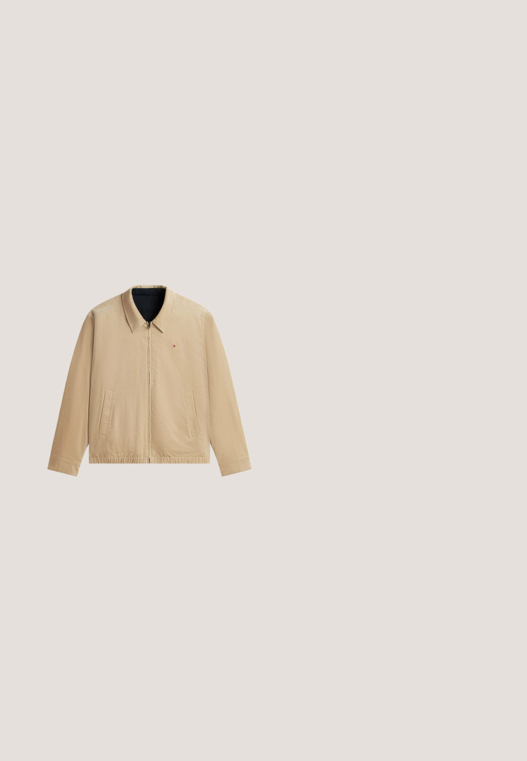Beige huejakke med lynlås og krave, to forlommer, elastisk kant og lille rød, hvid og blå logo på venstre bryst.; Lyseblå langærmet rundhalset sweater med lille broderet logo på venstre bryst og ribstrikkede manchetter og kant.; Lyseblå langærmet skjorte med knapper, lille krave og lille logo på venstre bryst mod hvid baggrund.; Mørkeblå denim jeans med slim fit, fem lommer og en standard taljehøjde. Har synlige syninger og metal hardware detaljer.; Mørkeblå ruskinds Chelsea-støvle med elastisk sidepanel, trækstrop på bagsiden og lav stablet hæl på en ensfarvet lys baggrund.; Tote bag lavet af hvidt lærred med marineblå accenter. Har to robuste håndtag og et logo-patch på fronten. Firkantet form.
