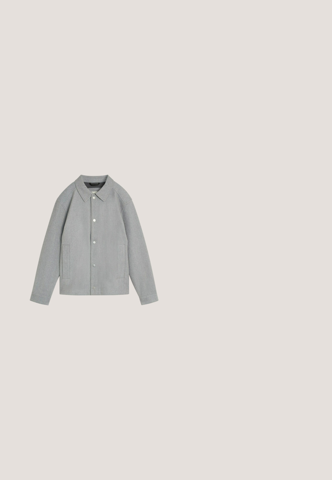Tela gris suave con tres botones a presión plateados dispuestos verticalmente a lo largo de una costura, mostrando textura y pliegues.; Camisa de manga larga gris con tejido de punto texturizado, cuello redondo y ribete blanco en el collar. Corte relajado con puños acanalados.; Camisa polo gris con cuello y acentos en las mangas en negro. Cuenta con cierre de tres botones y un pequeño parche de logo en el pecho. Tejido de mezcla de algodón.; Pantalones rectos para hombre en color gris oscuro con bolsillos frontales y traseros, trabillas para cinturón y cierre con botón.; Botas de tobillo grises para hombres, hechas de cuero, con un cuello forrado de piel, costuras decorativas y una suela de goma texturizada.; Bolso bandolera de cuero negro texturizado con un compartimento con cremallera y correa ajustable; cuenta con un bolsillo delantero y una etiqueta de marca en la parte frontal.