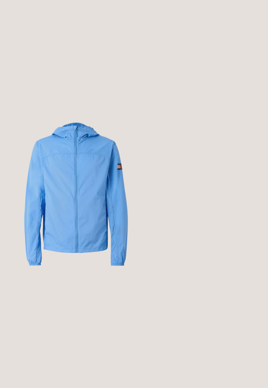 Hellblaues Jacket mit Kapuze, durchgehendem Reißverschluss, elastischen Bündchen und einem Logo-Patch am linken Ärmel. Glatte Textur und leichtes Material.; Marineblauer V-Ausschnitt-Pullover aus weichem Material mit langen Ärmeln. Besitzt ein kleines Logo auf der Brust sowie gerippte Bündchen und Saum.; Schwarzes Langarm-Polohemd mit beigem Kragen, das "HILFIGER Racing Club" in weißen Buchstaben und einem roten bestickten Logo-Detail zeigt.; Gestreifte Shorts in Marineblau und Weiß, mit Gürtelschlaufen, Knopfverschluss, zwei Seitentaschen und geradem Schnitt, der knapp über dem Knie endet.; Braune Leder-Halbstiefel mit metallischen Ösen, braunen Akzenten, einer stabilen Gummisohle und einer gerillten Zwischensohle für besseren Halt.; Marineblaue Tragetasche mit breiten cremefarbenen Griffen und dem "TOMMY JEANS"-Logo, das auf der Vorderseite in der Mitte eingestickt ist.