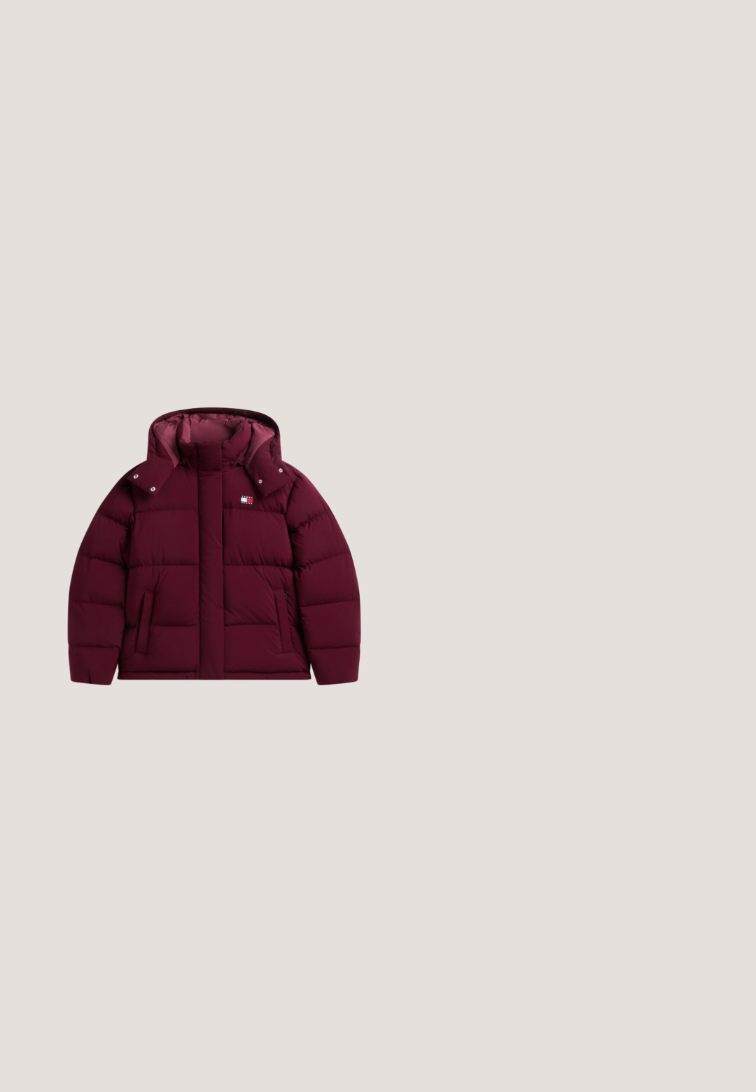 Veste d’hiver matelassée bordeaux avec capuche, fermeture zippée à l’avant recouverte d’un rabat à boutons, deux poches avant et un petit logo sur la poitrine.; T-shirt à manches courtes à rayures horizontales rouges et blanches avec col rond et petit logo sur le côté gauche de la poitrine, posé à plat sur fond blanc.; Jeans droits bleu clair en denim, dotés d'une fermeture à bouton, de cinq poches et d'un léger dégradé le long des jambes.; Baskets blanches Tommy Hilfiger à semelle épaisse et lacets, présentées au-dessus d'un sol en bois à motifs et de galets en plein air.; Sac fourre-tout blanc avec deux longues poignées, texture lisse, design minimaliste, arborant un petit logo multicolore sur le devant.; Boucles d'oreilles en argent avec un design lisse et arrondi, accentuées par une petite rayure rouge, blanche et bleue. Fermoir à tige sécurisé.