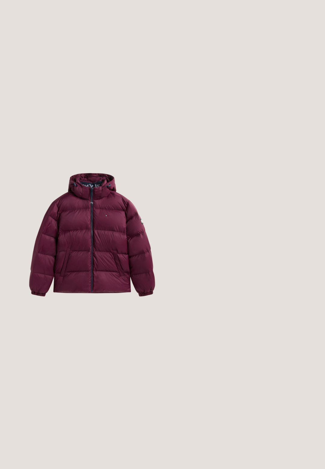 Chaqueta acolchada granate con capucha, cremallera completa en la parte delantera, dos bolsillos laterales, puños elásticos y pequeño logo en el pecho y la manga.; Sudadera con cremallera de color marrón hecho de tela suave, que cuenta con un bolsillo tipo canguro en la parte delantera, una capucha con cordón y un logotipo bordado en verde en el pecho.; Polo de manga corta de color burdeos oscuro con ribete blanco en el cuello, la tapeta y las mangas, con un pequeño logo bordado en el pecho.; Pantalones cortos de punto en burdeos oscuro con cintura elástica y bolsillos laterales, con un pequeño logo verde de cocodrilo en el lado izquierdo.; Zapatilla deportiva de piel verde oscuro con suela de goma marrón, cordones en la parte delantera y pequeño logo de cocodrilo en el lateral.; Bolsa rectangular verde oscura con cremallera y pequeño logo de cocodrilo bordado en la parte frontal derecha.