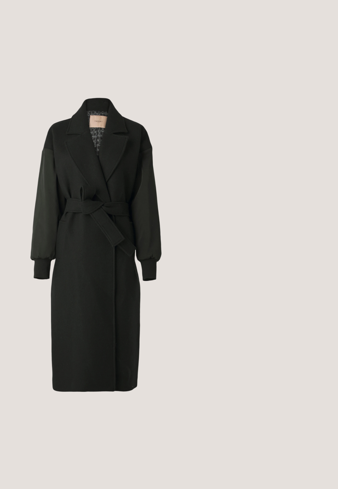 Abrigo negro con cuello entallado, cintura ceñida y mangas largas abullonadas. Hecho de una mezcla de materiales, con un forro interior texturizado.; Vestido negro con mangas largas, escote en V y cintura fruncida. Presenta una falda con volantes y sutiles rayas texturizadas en toda la prenda.; Zapato slingback de charol negro con tacón bajo, punta puntiaguda y correa ajustable con hebilla dorada sobre fondo blanco.; Gafas de sol negras con montura rectangular y lentes degradados. Presenta el logo dorado "DG" en la patilla. Material de plástico suave.; Bolso Love Moschino de cuero negro texturizado con herrajes dorados, asa corta en la parte superior y correa de hombro desmontable sobre un fondo liso.; Pendientes de oro con un diseño en capas, con un contorno en forma de concha y pequeñas piedras. Se sujetan con un cierre de aro para un uso seguro.