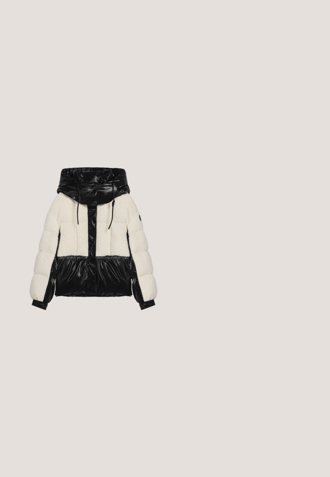 Chaqueta de plumón con un frente negro brillante, mangas y capucha; cuerpo de color crema y suave; presenta un cierre con cremallera y botón a presión.; Sudadera de forro polar negro con cuello alto, cierre de cremallera y puños de canalé. Presenta un acabado texturizado y detalles bordados en la parte frontal.; Blusa de manga larga con cuello alto, que presenta un diseño de estampado de cebra en blanco y negro sobre un tejido transparente. Acentos con volantes en el escote y los puños.; Pantalones de imitación de cuero negros con un corte relajado, cintura elástica, cordón y piernas ajustadas, con detalles de costura y sin bolsillos.; Botines negros de cuero con paneles laterales elásticos, suela gruesa con plataforma y detalles texturizados en la suela.; Bolso negro de hombro fabricado con material brillante, con forma redondeada, correa ajustable, bolsillo frontal y acentos texturizados.