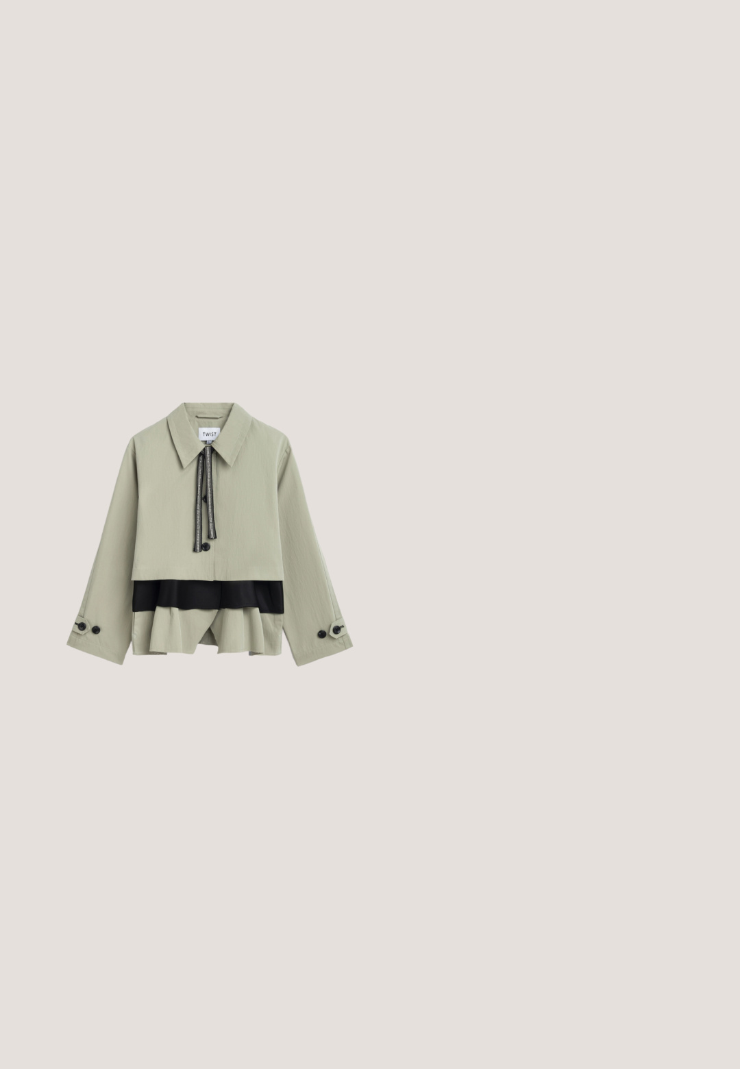 Beige cropped jack met brede kraag, zwarte trekkoordsluiting, zwart gelaagd paneel eronder en geruite manchetten aan lange mouwen.; Mouwloos lichtgroen hemdje met ronde halslijn, gladde stof en subtiel logodetail aan de onderzoom.; Plissé rok in donkergroen met zwart luipaardpatroon. Elastische tailleband, lichtgewicht stof en vloeiende stijl. Uitlopende silhouet.; Beige hoge hakken mules met een gespsluiting. Beschikt over een vierkante neus, een gladde textuur en een slanke hak met een gouden accent aan de basis.; Donkergroene suède handtas met een bovenhandvat, gouden gespsdetail en een verstelbare schouderriem op een lichte achtergrond.; Oorbellen in goud- en zilvertinten met verweven cirkelvormen en een gladde metalen afwerking. Lichtgewicht ontwerp, geschikt voor dagelijks gebruik.