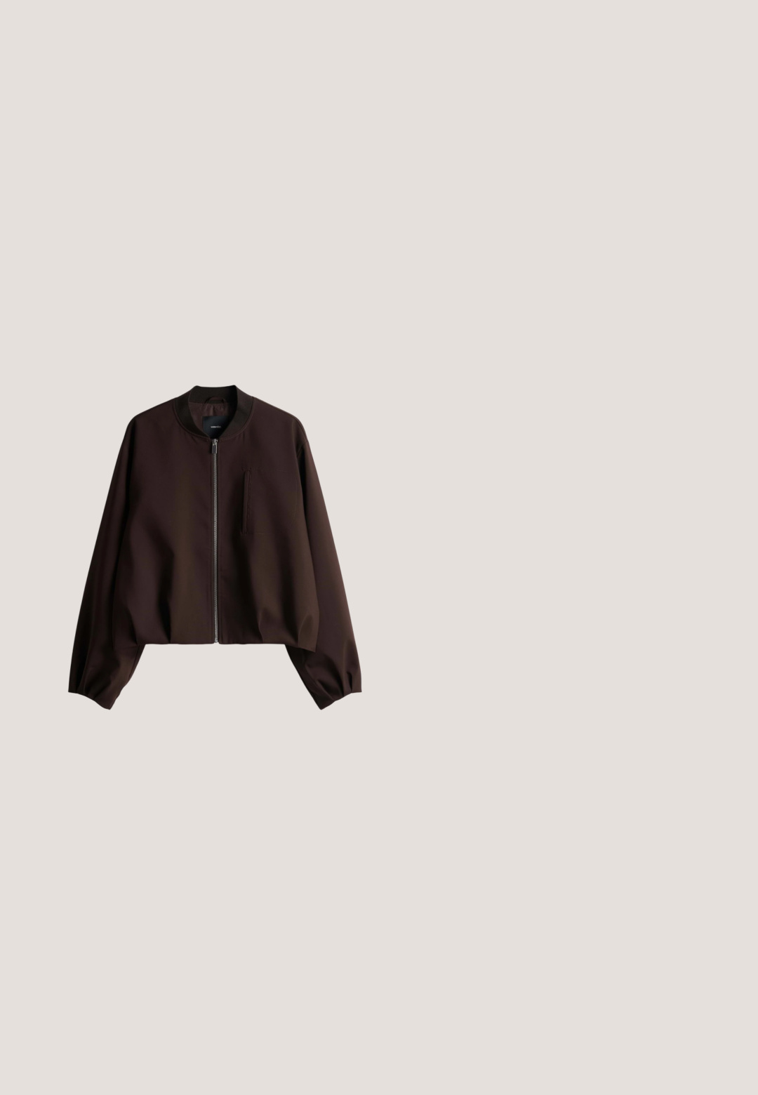 Bruine bomberjas met een rits aan de voorkant, een cropped ontwerp, geribbelde kraag en een borstzak. Gemaakt van glad, lichtgewicht materiaal met een matte afwerking.; Zwarte linnen korte mouwen overhemd met een button-down voorkant, voorzien van een enkele borstzak en contrasterende knoopkleuren.; Donkerbruine losse broek met elastische taille en trekkoord, met zijzakken en rechte wijde pijpen.; Bruine leren slide-sandaal met een kruisgesp aan de bovenkant, platte zool en subtiele gouden accenten voor extra detail. Glad oppervlak door de hele sandaal.; Bruine leren schoudertas met een brede enkele band en een soepel, lichtjes ingezakte rechthoekige vorm.; Ring van metaal met goudkleurige tint, met een dik, golvend, abstract ontwerp en een open, verstelbare band.