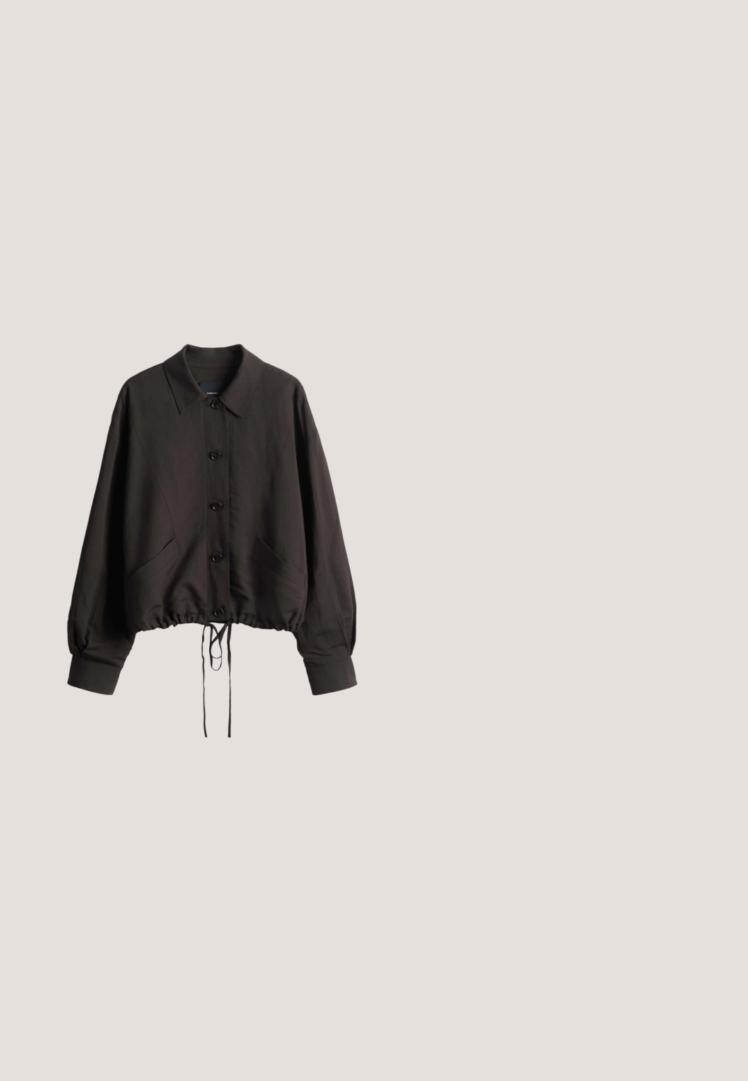 Zwarte blousejas met lange mouwen, kraag, twee voorzakken en verstelbare trekkoorden aan de zoom.; Zwarte mouwloze jumpsuit met dunne bandjes, een geplooide elastische taille en wijde broekspijpen, afgebeeld op een witte achtergrond.; Zwarte flip-flop met een gestructureerde band, een gevoerde zool en een strak, minimalistisch ontwerp. Geschikt voor casual gebruik.; Zwarte rechthoekige zonnebril met donker getinte glazen en dikke monturen tegen een witte achtergrond.; Zwarte gevlochten leren schoudertas met enkele gevlochten riem en zachte, slappe driehoekige vorm tegen een witte achtergrond.; Zwart verstelbaar touwarmbandje met een metalen sluiting in goudkleur en een ronde hanger gegraveerd met "CPH STUDIOS."