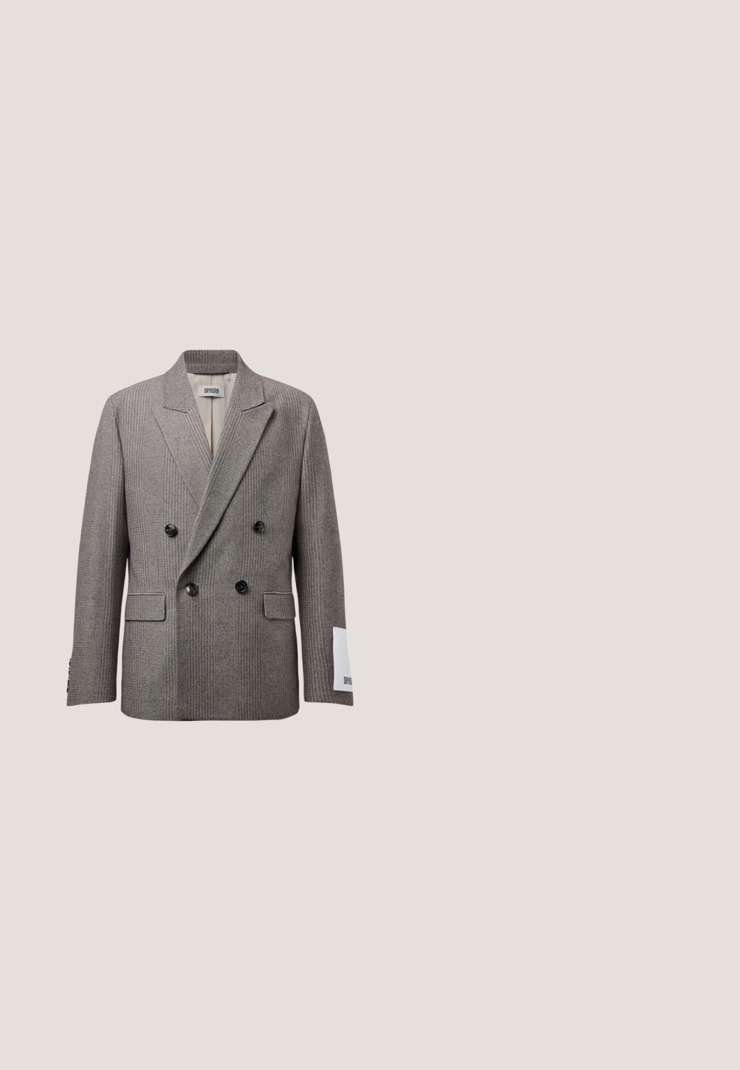Blazer gris en chevrons à double boutonnage avec larges revers, boutons noirs, poches à rabat, et une étiquette blanche sur la manche droite.; Chemise grise à manches longues avec des rayures verticales blanches, fermeture boutonnée devant, col pointu, poche poitrine et manches avec poignets.; Pantalon habillé gris slim fit avec fines rayures verticales discrètes, fermeture à boutons sur le devant et passants de ceinture.; Chaussure habillée en cuir noir à lacets, semelle épaisse à crampons, bout arrondi et petit talon, vue de côté sur fond blanc.; Sac fourre-tout gris avec impression de façade d’un bâtiment parisien, deux anses, bandoulière réglable, et étiquette « Karl Lagerfeld Paris » à l’avant.; Ceinture en cuir noir avec une finition texturée, boucle rectangulaire en métal noir et bords lisses, dotée d'une boucle pour le surplus de ceinture.