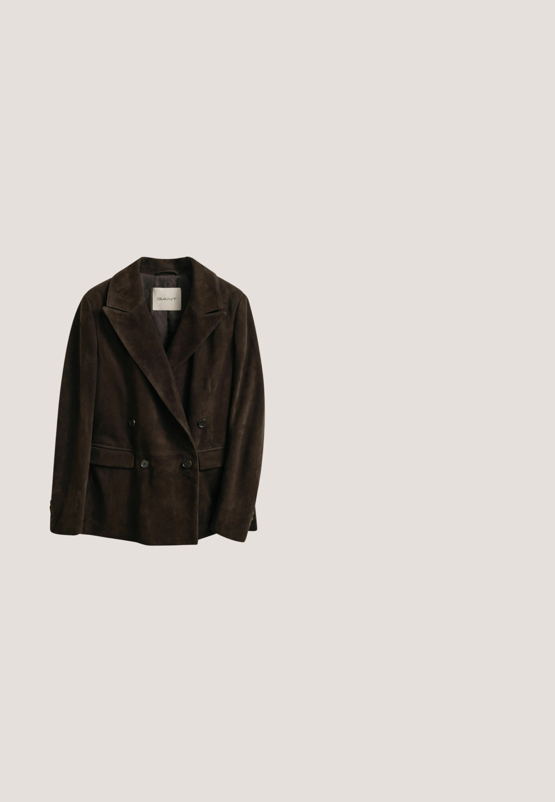Donkerbruine suède dubbelzijdige blazer met klepkragen, vier knopen aan de voorkant en klepzakken, met het label GANT aan de binnenkant van de kraag.; Lichtblauwe spijker blouse met lange mouwen, puntige kraag, twee borstzakken, knoopsluiting en subtiele textuur. Geen zichtbare patronen.; Lichtblauwe, wijd uitlopende spijkerbroek van denim. Verbleekte delen op de dijen en knieën. Standaard tailleband met vijf zakken en metalen accenten.; Bruine leren cowboylaars met een puntenneus en gestapelde hak. Voorzien van een decoratief ruitpatroon en een riem met hardware accent.; Vierkante roestkleurige sjaal met witte en oranje bloemenrand en witte cursieve tekst "Andiamo Amore Mio" in het midden.; Bruine suède riem met gesmede gouden gesp, vijf verstelgaatjes en "Lee" geperst op het uiteinde van de riem.