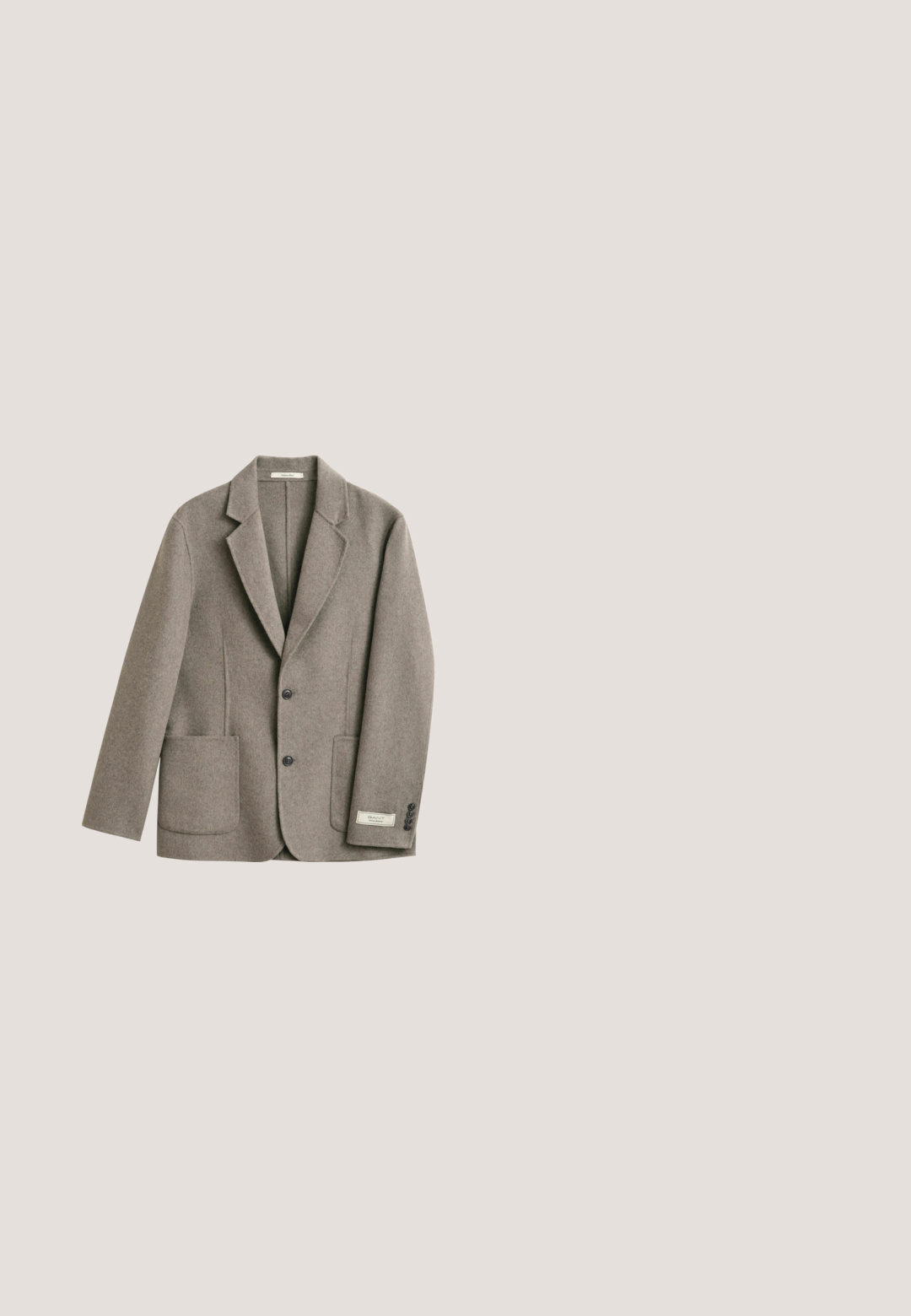 Enkelttradet grå uldblazer med hakrevers, to frontede påsyede lommer, to knapper og manchetter med knapper på hvid baggrund.; Beige ribstrikket sweater med lange ærmer og rund halsudskæring, vist mod en lys baggrund.; Beige langærmet skjorte lavet af struktureret stof, med en klassisk krave, knaplukning og en afslappet pasform.; Khaki chinos med en glat tekstur, lige ben design, forlommer og knaplukning. Struktureret talje med bæltestropper.; Herre tanfarvede ruskindslædersko uden snørebånd med hvid gummisål og subtile syningsdetaljer langs siderne og toppen.; Brunt læderbælte med sølvmetal spænde indgraveret med "JACK & JONES," rullet sammen mod en ensartet lysegrå baggrund.