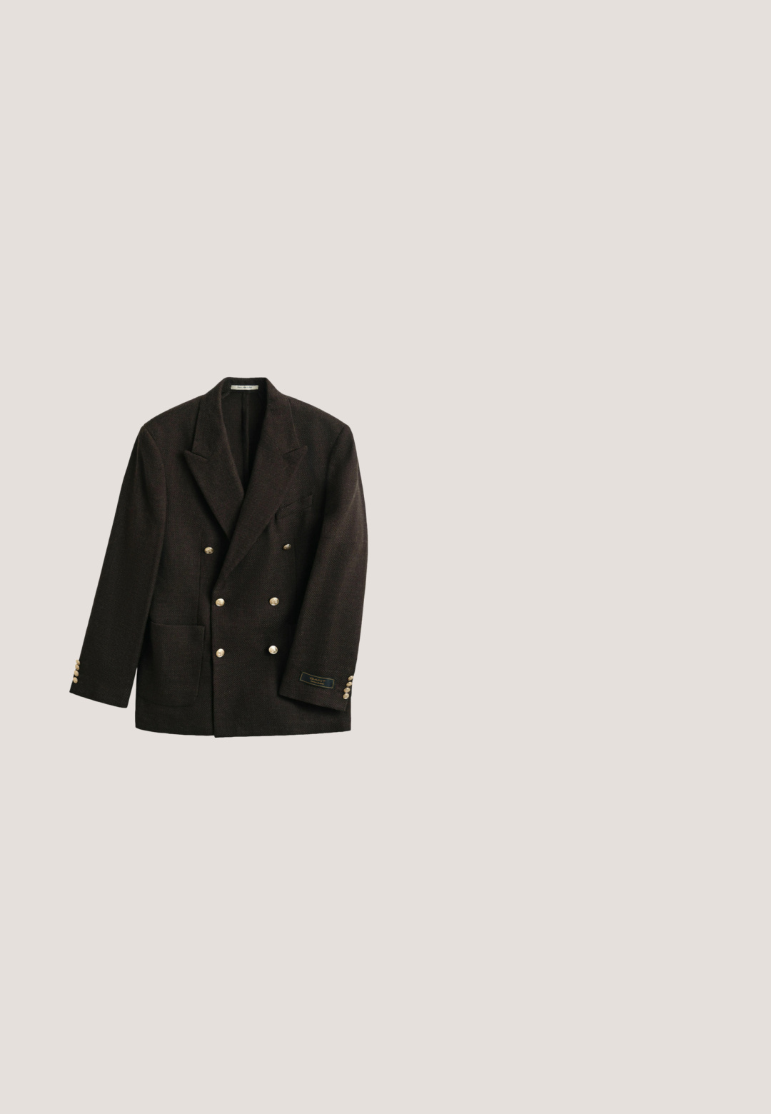Donkerbruine, dubbelrijige blazer met brede revers, goudkleurige knopen, een opgestikte zak en een klein label op de linker mouwmanchet.; Crèmekleurige kabelgebreide trui met een kwartrits en een klein geborduurd marineblauw logo op de linkerborst.; Wit overhemd met lange mouwen, knopen en kraag, met Polo Ralph Lauren-logo geborduurd op de linkerborst.; Bruine textuurbroek met een recht gesneden ontwerp, voorplooien en een knoopsluiting. Gemaakt van een duurzame stof, geschikt voor casual kleding.; Zwarte leren loafer met kwastje, lage hak en gestikte details op een witte achtergrond.; Zwarte leren aktetas met een gladde textuur, dubbele handgrepen, zilverkleurige hardware en een afneembare schouderriem. Rechthoekige vorm met ritssluiting.