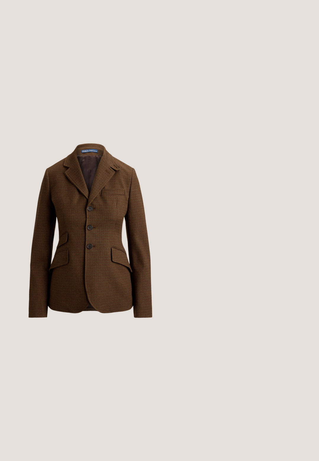 Hnedé sako s vzorom psieho zuba, so zárezovým golierom, tromi prednými gombíkmi, dvoma klopovými vreckami a jedným náprsníkom, od Polo Ralph Lauren.; Krémový pletený sveter s diamantovým vzorom, dlhými rukávmi, vlnitým lemom a golierom na tri gombíky.; Olivovo zelená midi plisovaná sukňa so širokým, hladkým pásom a rovnomerne rozmiestnenými úzkymi záhybmi.; Tmavo hnedá kožená topánka s dvojitými sponami, perforovaným dizajnom špičky a hrubou priesvitnou podrážkou so žltým prešívaním.; Štvorcový šál s oranžovým pozadím, veľkou ilustráciou slnka a dúhovým pruhom pozdĺž jedného okraja, zložený do kruhovej formy.; Hnedá kožená crossbody taška so zapínaním na klopu, strieborným prackovým detailom a kontrastným prešívaním. Hladká textúra a obdĺžnikový tvar.