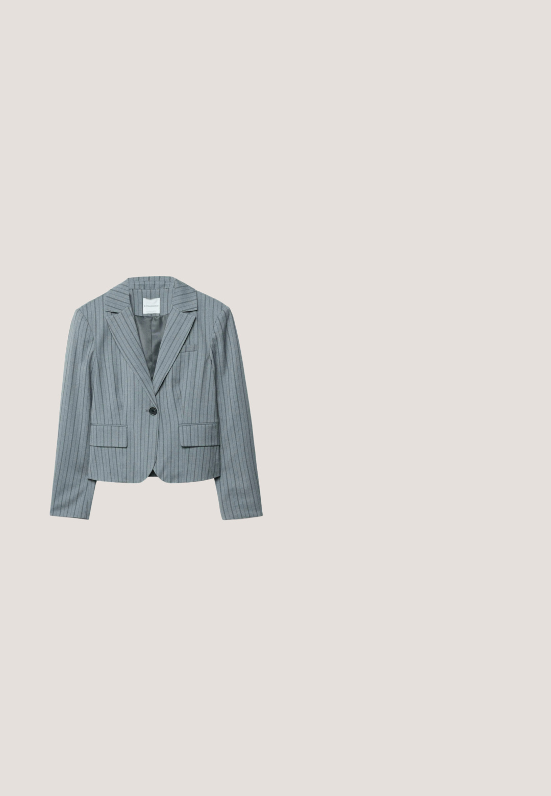 Blazer gris à rayures fines avec un col cranté, une fermeture à un bouton, deux poches avant et une doublure intérieure lisse.; Haut sans manches gris clair avec fines bretelles et petites paillettes brillantes éparpillées sur la partie supérieure de la poitrine en forme de V.; Pantalon large en maille gris clair avec une taille épaisse et texturée. Le tissu présente un motif subtil et une coupe ample et décontractée.; Chaussure plate tissée argentée avec bout pointu et boucle de bride à la cheville sur fond blanc.; Lunettes de soleil carrées à monture métallique avec des branches fines argentées et des verres dégradés gris foncé sur fond blanc.; Petit sac à main argenté pailleté avec une anse nouée et une fermeture éclair, présentant un détail de chaîne latérale.