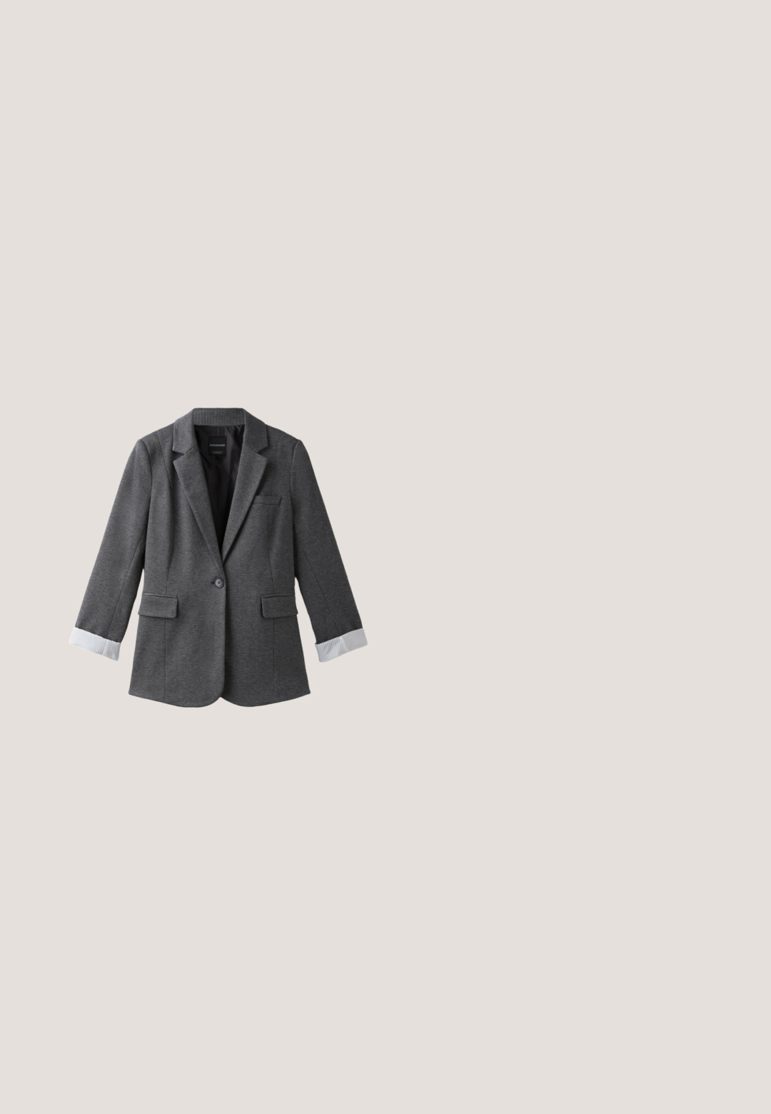 Mørkegrå blazer med én knap, notched revers, lommer med klap og hvide manchetter, der viser sig ved ærmerne.; Mørkegråt uldponcho med brede ærmer og rund halsudskæring vist mod en hvid baggrund.; Sort t-shirt med korte ærmer og rund hals lagt fladt på hvid baggrund, der viser forfra og glat stoftekstur.; Grå teksturerede bukser har en knaplukning, lynlås og stofbæltestropper, med en hvid indvendig foring og markante stikninger.; Grå filtsko med en sort gummisål. En dekorativ rem med sølvhardware tværs over toppen. Glatte læderdetaljer ved hælen.; Sort suede håndtaske med rund top, korte håndtag og subtilt prægede logo. Har kontrasterende sorte syninger og en struktureret form.
