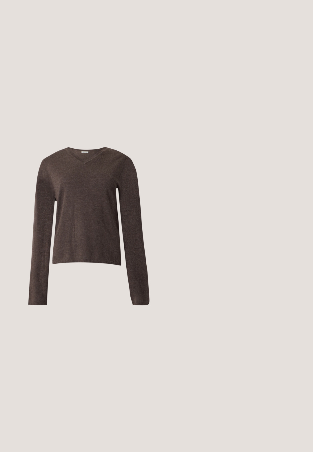 Bruine V-hals trui met lange mouwen, een eenvoudige gebreide structuur en geribbelde boorden en zoom, weergegeven op een effen lichte achtergrond.; Donkerblauw denim overhemd met lange mouwen, sluiting met knopen aan de voorkant en twee borstzakken met knopen, tegen een effen grijze achtergrond.; Donkerblauwe straight-leg jeans gemaakt van denim, met een klassieke vijf-pocketontwerp, gestikte details en een knoopsluiting bij de taille.; Pumps met een spitse neus van glad lichtbruin leer. Voorzien van een afgeronde lage hak met een bolvormige uitstraling. Minimalistisch ontwerp, zonder zichtbare versieringen.; Beige nylon handtas met een vouwontwerp, een gouden sluiting en een afneembare schouderband. Zachte textuur en een platte vorm met minimale detailing.; Glad zilveren ring in de vorm van een decoratieve knoop met overlappende lussen, tegen een effen witte achtergrond.