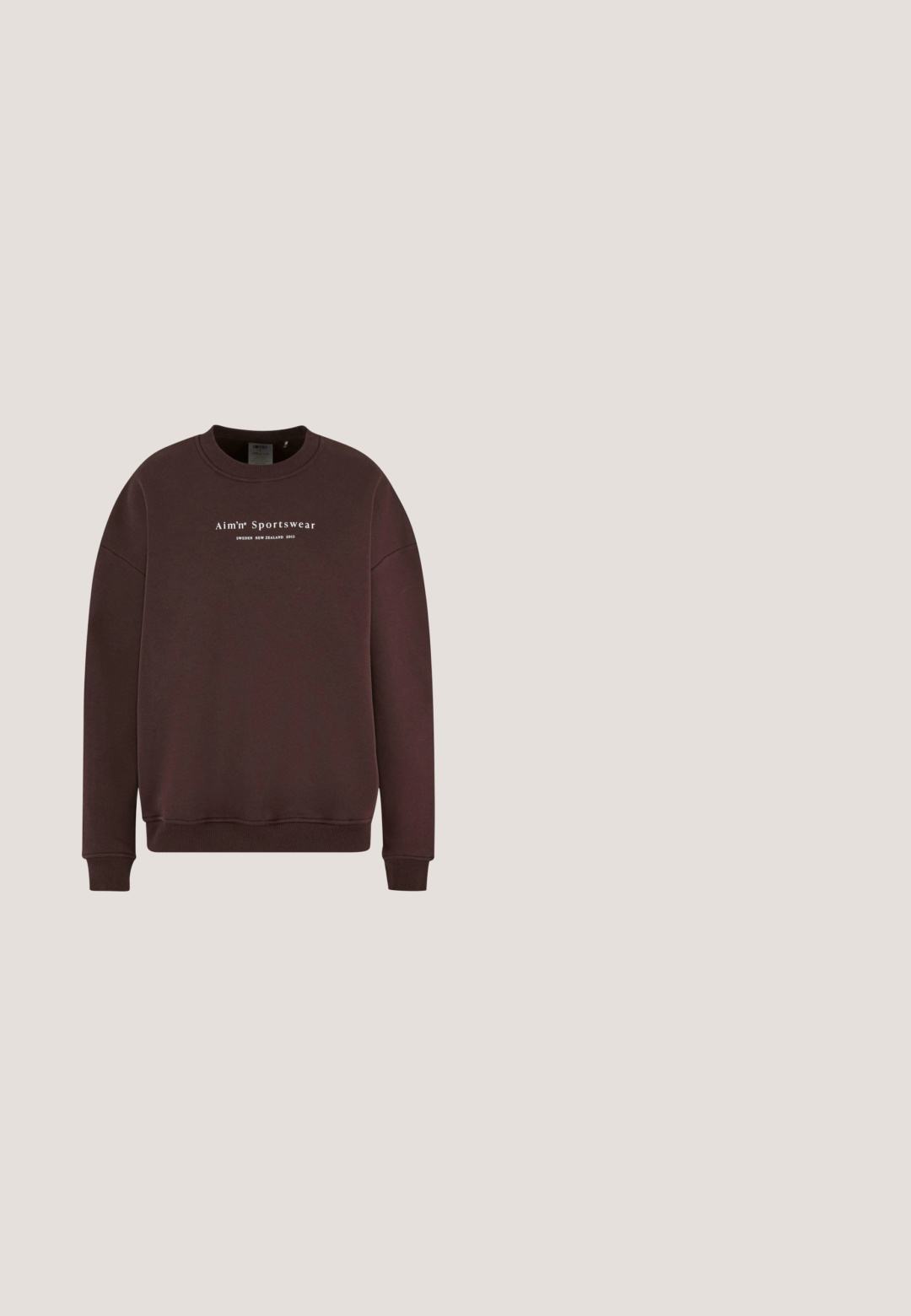 Pruun kapuutsiga sweatshirt, millel on ümmargune kaelus, pikad varrukad ja soonikud. Eespool logo tekst "Aim'n Sportswear Sweden New Zealand 2013."; Gestuz DREW - Polosärk - aronia; Helepruunid kõrge piha ja sirgete jalgadega teksad ees oleva nupu ja lukuga, ees- ja tagataskutega, valgel taustal esitatud.; Prunat suled jalatsid mustade kummitaldade, metallist silmade ja paeltega. Kombineeritud laiemate beežide pükstega, mis näitavad riietuse alumist osa.; Bordoo nahast käekott tekstuuriga viimistlusega, kahe lühikese käepideme ja eemaldatava õlarihmaga, millel on hõbedane lukudetail.; Hõbedased kõrvarõngad, millel on kaks omavahel ühendatud silmust: üks poleeritud ja teine väikesete läbipaistvate kivikestega, luues tekstuurilise kontrasti.