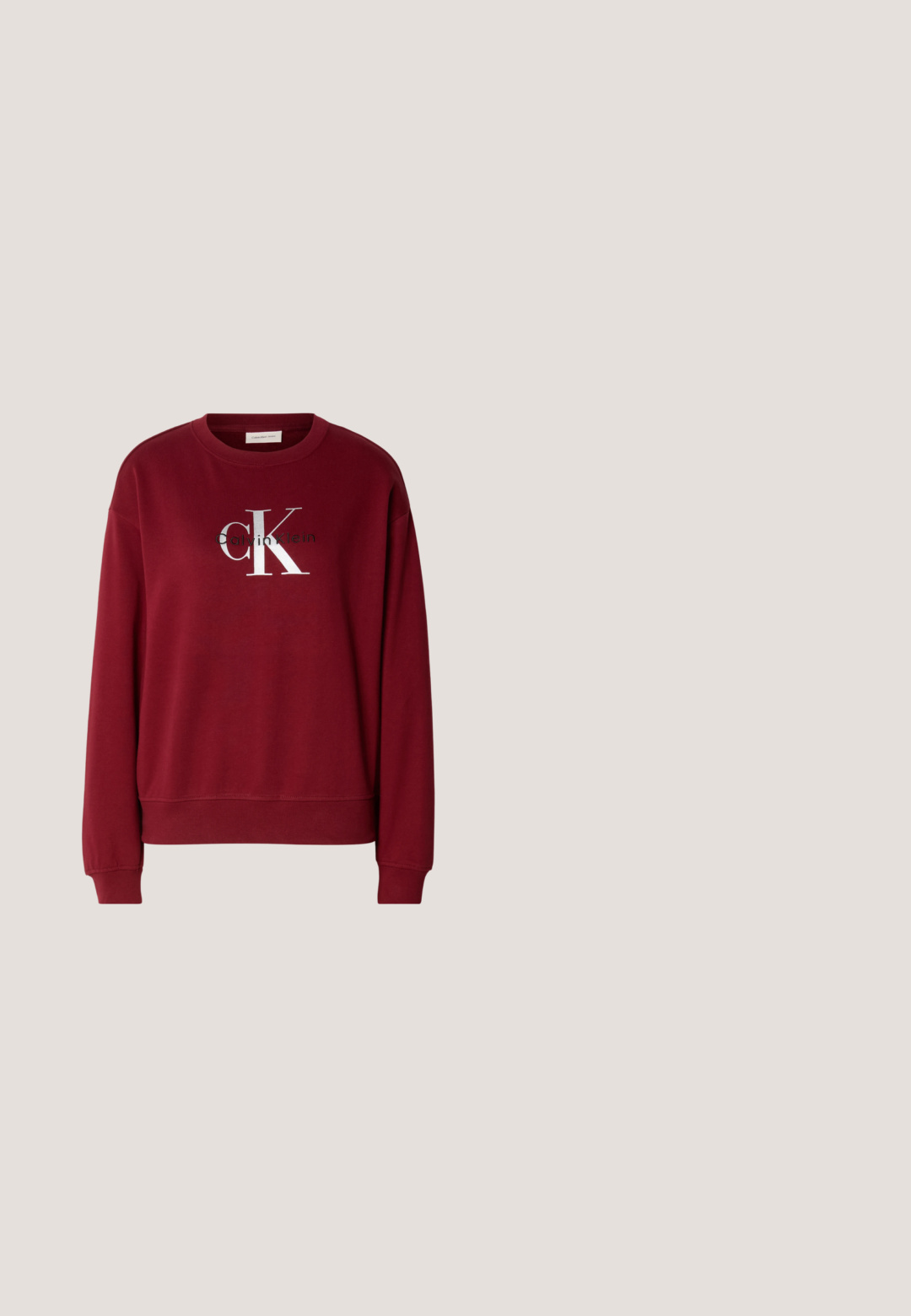 Bordeaux sweatshirt met een ronde hals, lange mouwen en een zilveren "Calvin Klein" logo. Zachte stof met een ontspannen pasvorm en geribbelde manchetten.; Zwart katoenen T-shirt met een ronde hals en korte mouwen, met de tekst "Calvin Klein Jeans" in wit over de borst.; Lichtblauwe jeans met wijde pijpen, voorzien van een knoop- en ritssluiting aan de voorkant, voor- en achterzakken, en subtiele vervaagde details op de dijen en knieën.; Zwarte leren enkellaars met een spitse neus, blokhak en een bandje met een metallic logo. Gladde textuur en minimalistisch ontwerp.; Zwarte Calvin Klein leren schoudertas met brede verstelbare band met herhaald Calvin Klein-logo in beige.; Twee delicate zilveren armbanden naast elkaar, één met kleine kralen en de andere met een dun gevlochten ketting, beide voorzien van karabijnsluitingen en labels.
