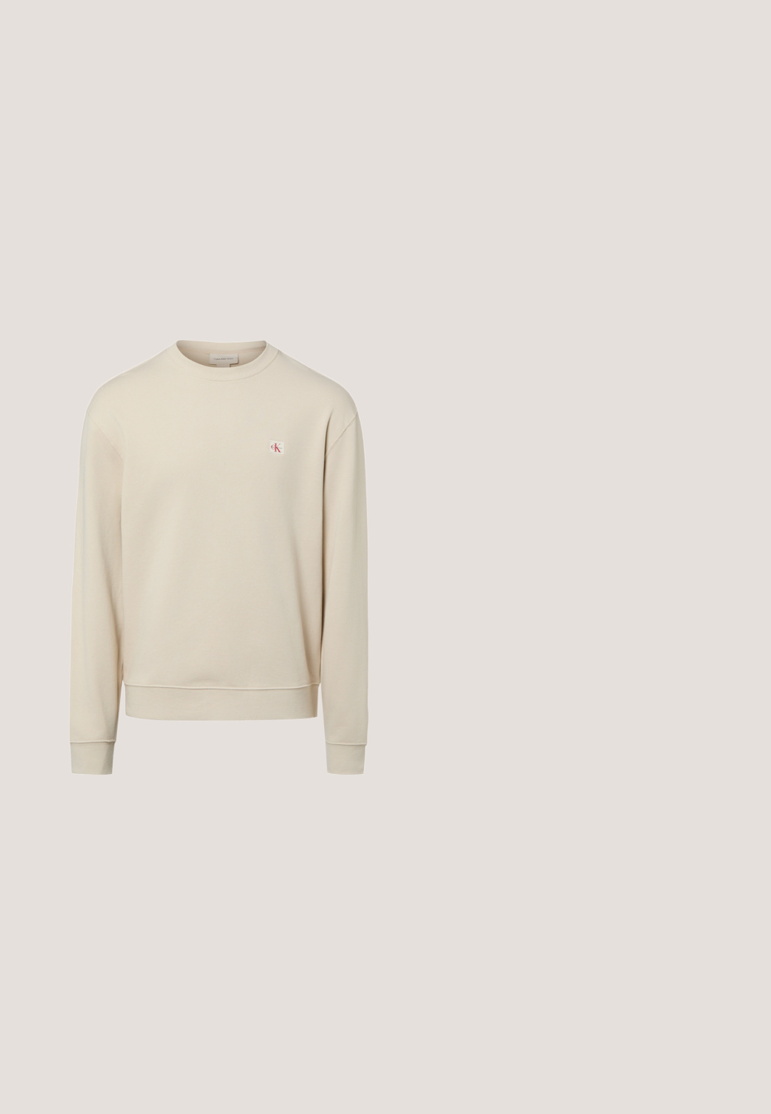 Sweat-shirt beige à manches longues avec col rond et petit logo CK rouge et blanc sur la poitrine gauche.; Chemise boutonnée à manches longues vert olive foncé avec col pointu et deux poches poitrine sur fond gris clair.; Shorts en denim bleu clair avec revers roulés, bouton frontal, fermeture éclair, et design à cinq poches sur fond blanc.; Bottines en daim beige avec semelle en caoutchouc noir, design à lacets, et un petit logo embossé sur le côté, avec une languette à l'arrière.; Lunettes de soleil carrées brun foncé avec des montures épaisses et des branches légèrement inclinées reposant sur une surface gris clair.; Sac bandoulière compact vert olive avec poche avant, sangle noire réglable, fermeture zippée et plaque logo Calvin Klein.