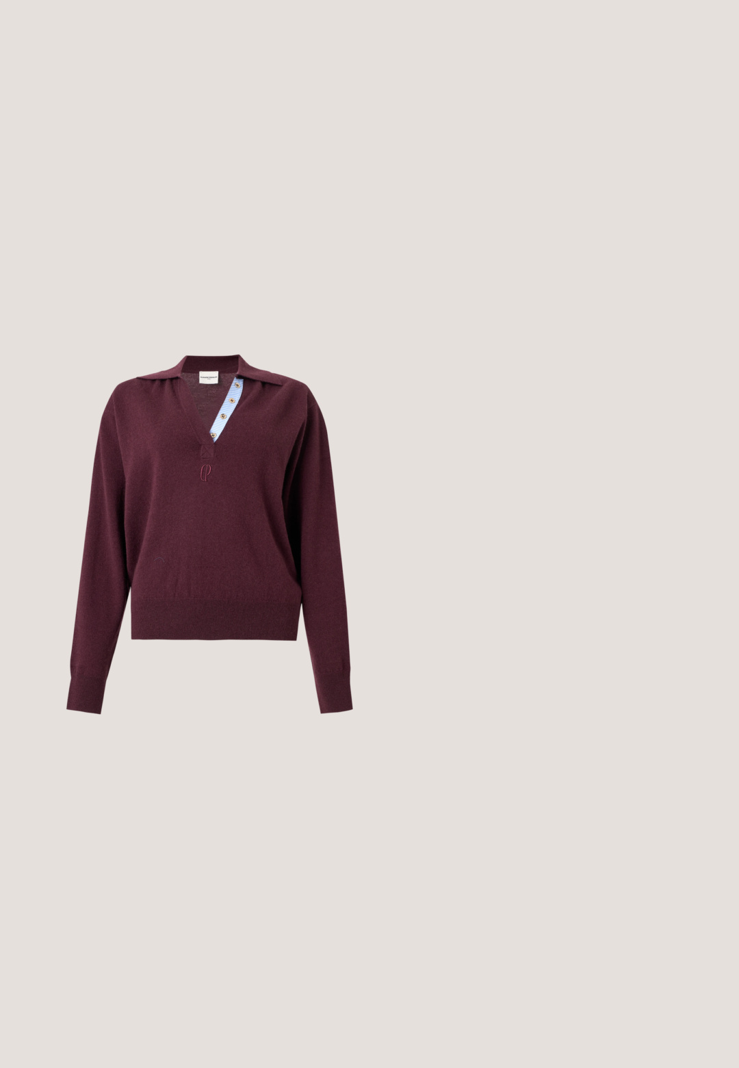 Langærmet bordeauxstrikket sweater med dyb V-hals, der viser en blåstribet indvendig knapstolpe og et lille broderet logo under halsudskæringen.; Mørkebrun langærmet skjortejakke med spids krave og fem dækkede knapper ned foran på en lys baggrund.; Bredde ben bukser i lys grå kunstlæder med en knaplukning foran, to sidelommer og syningdetaljer for ekstra struktur.; Ballethæle i bordeaux laklæder med spids tå og en dekorativ lilla sløjfe på forfoden; flad såldesign.; Mørk bordeaux læderhåndtaske med tekstureret mønster, sort topgreb, guldfarvet hardware og aftagelig skulderrem på hvid baggrund.; Et par guldfarvede creoler med afrundede perle-detaljer langs den ydre kant på en lys baggrund.
