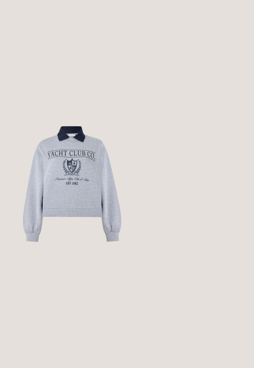 Lysegrå sweatshirt med lange ærmer og mørkeblå krave, med teksten "Yacht Club Co.", Monaco-våbenskjold og printet "Provence Alpes Côte d'Azur EST 1982."; Sort kortærmet t-shirt med rund halsudskæring. Har et hvidt grafisk motiv af en sol samt teksten "Taknemmelig for hver lille ting." Blødt stof.; Mørkegrå denim mininederdel med lige snit, elastisk talje og subtile syningsdetaljer på ensfarvet baggrund.; Grå og lysegrå sneakers med en struktureret overdel, polstret tunge og sorte detaljer. Har en tyk hvid skummellemsål og sort ydersål.; Grå fløjlsnettaske med lange håndtag og en forreste lomme, sat mod en ensartet hvid baggrund.; Par mellemstore skinnende sølv hoops øreringe med tynde metal spænder på en lys neutral baggrund.