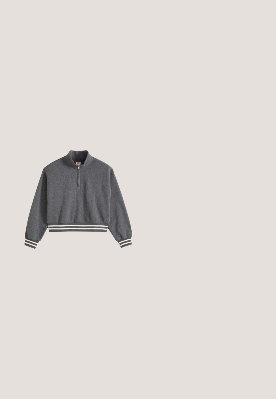 Donkergrijze cropped sweatshirt met een kwartrits, opstaande kraag, lange mouwen en gestreepte geribde manchetten en zoom.; Koolgrijs T-shirt met korte mouwen en "NEW BALANCE" in witte letters, gecentreerd net onder de bovenrug gedrukt.; Beige wijde jeans met een hoge taille, vijf-pocket ontwerp en knoopsluiting. De stof heeft een zachte textuur en een lichte vervaging aan de voorkant.; Lichtroze sneaker met een bovenwerk van mesh en suède accenten. Voorzien van beige veters en een gebogen zool, met een logo aan de zijkant.; Kleine rode krokodillenprint handtas met twee hengsels, ritssluiting en "Karl Lagerfeld Jeans" logo aan de voorkant.; Set van gouden oorringen met textuur en ronde kralenclusters, voorzien van een scharnierende sluiting, op een witte achtergrond.