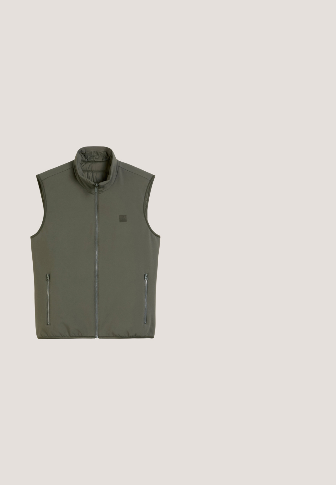 Ärmellose Weste in Olivgrün aus weichem Material. Mit hohem Kragen und zwei seitlichen Reißverschlusstaschen. Glatte Textur, minimalistisches Design.; Olivgrünes T-Shirt mit kurzen Ärmeln und Rundhalsausschnitt mit kleinem weißem "M OP"-Logo auf der linken Brust.; Graue Denim-Jeans mit einem ausgewaschenen Finish, gerade geschnitten, mit fünf Taschen und einer leicht abgenutzten Textur.; Schwarzer Ledersneaker mit grauen Wildledereinsätzen, weißem Fersen-Detail und einer Gummisohle. Verfügt über weiße Schnürsenkel und strukturierte Seitenpaneele.; Schwarze rechteckige Armani Exchange Sonnenbrille mit dunklen Gläsern und dünnen Bügeln, auf einer hellgrauen Oberfläche liegend.; Schwarze rechteckige Reisetasche mit zwei oberen Griffen, Frontreißverschlusstasche, silberfarbigen Schnallen und einem Reißverschluss entlang der oberen Kante.