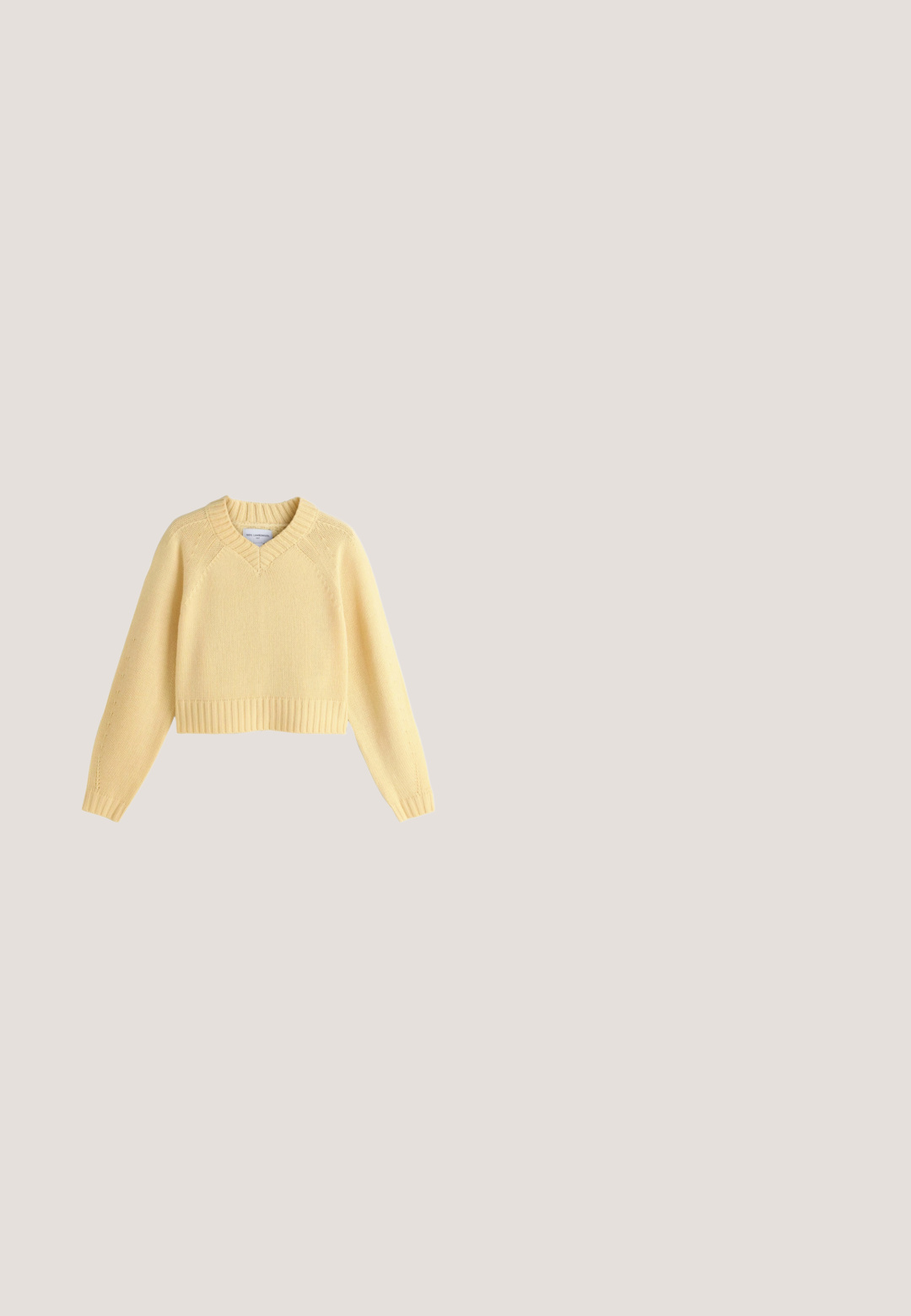 Gul cropped sweater lavet af 100% lammeuld, med V-udskæring, ribbede manchetter og kant, samt strukturstrik detalje på ærmerne.; Beige knap-up skjorte med krave, lange ærmer og to brystlommer. Har broderet logo og en glat, blød tekstur.; Lysblå vid ben jeans lavet af denim, med mellemhøj talje, to frontlommer og klassiske syninger.; Lavtop beige sneaker med vævet stof og ruskindsoverlejringer, gummisål og snørelukke mod en hvid baggrund.; Beige læder skuldertaske med justerbar rem og lynlåslukke, vist mod en lys beige baggrund.; Guldtonet metal kæde med et snoet design. Udstyret med en klo-lås og forlængede led, arrangeret i et flydende, kurvet layout.