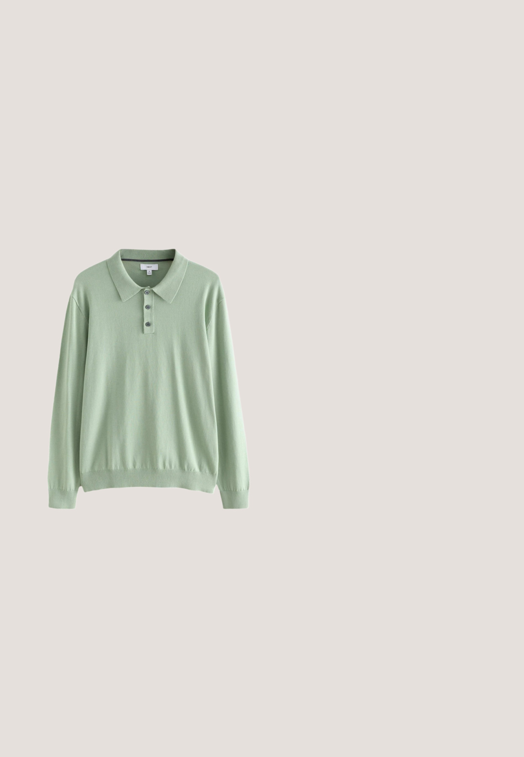 Hellgrüner Langarm-Polo-Pullover aus weichem Material. Mit Kragen und Drei-Knopf-Leiste. Gerippte Bündchen und Saum.; Weißes Langarm-Hemd mit Knöpfen aus Baumwolle, ausgestattet mit einer Brusttasche mit tonalem Stickerei, einem Kragen und Knopfmanschetten.; Olivgrüne Baumwollhose mit geradem Bein, ausgestattet mit einem vorderen Knopfverschluss, seitlichen Taschen und minimalen Nähten.; Schwarzer Lederschuh ohne Schnürsenkel schwebt über einem beigen gewebten Teppich, im Hintergrund ein runder Holztisch und ein Sofa.; Silberfarbener Halsreif mit einer Reihe klarer, symmetrischer Strasssteine, die in einer schlanken, flexiblen Kette mit einem glatten Verschluss gesetzt sind.; Gerollter schwarzer glänzender Ledergürtel mit einer silbernen rechteckigen Metallschnalle auf hellem einfarbigem Hintergrund.