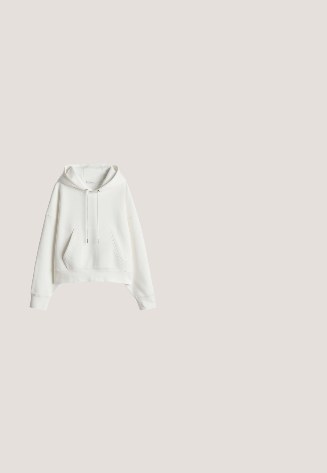 Witte cropped hoodie gemaakt van zachte stof, met een zak aan de voorkant, capuchon met trekkoord en geribde manchetten. Eenvoudig en onopgesmukt ontwerp.; Groene button-up overhemd van zachte stof met een kraag, twee voorkruiszakken en lange mouwen met manchetdetails.; Beige broek met rechte pijpen, knoop- en ritssluiting, riemlussen, opgestikte voorzakken en enkellange zoom.; Witte lage sneaker met dikke zool, gouden metalen hielstuk, witte veters en een glad leren bovenzijde, getoond in zijaanzicht.; Kleine taupe leren schoudertas met een gebogen vorm, gestikte klepsluiting, verstelbare riem en een zilverkleurig "RYŁKO" logo aan de voorkant.; Gouden oorbellen in de vorm van harten, met afwisselend baguette-slepen heldere stenen. Twee harten in graduele maten met een gepolijste afwerking.