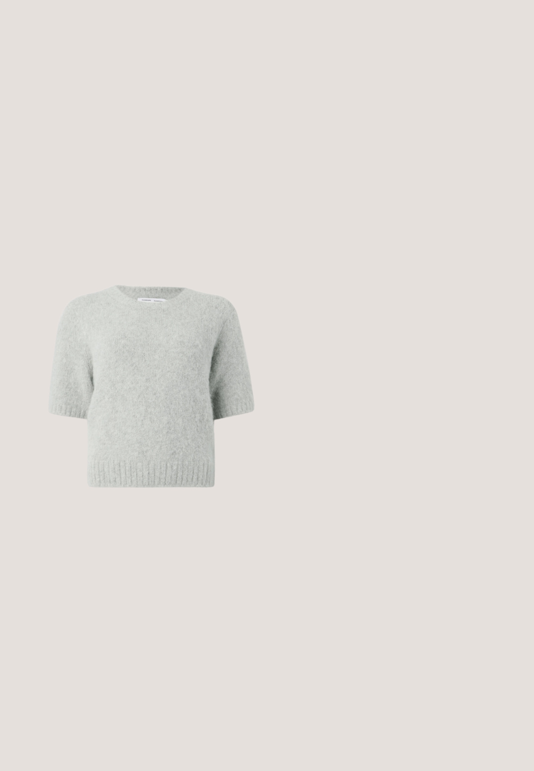 Hellgrau, kurzärmliger Pullover aus weichem, samtigem Material mit rundem Halsausschnitt und geripptem Saum. Minimalistisches Design ohne Muster oder Akzente.; Schwarzes Maxikleid aus Spitze mit dünnen Spaghettiträgern, tailliertem Oberteil, weiter Rock und kunstvollem Spitzenmuster im gesamten Stoff.; Schwarzer Lackleder-Pumps mit hohem Absatz, spitzer Zehenpartie, Knöchelriemen mit Schleife verziert und schlankem Stiletto-Absatz.; Runde Sonnenbrillen mit transparenten grauen Fassungen und grau getönten Gläsern. Metallakzente an den Bügeln und gebogene Arme für Stabilität.; Schwarzer wollener Umhang mit einem eckigen Design, das mit drappiertem Stoff versehen ist, der zu einer Spitze verjüngt. Etiketten sind im Nackenbereich sichtbar.; Schlichtes, silbernes Twisted-Ohrschmuckdesign mit zarten Kurven, das kleine klare Strasssteine entlang der Oberfläche zeigt. Mit Clip-Verschluss für sicheren Halt.